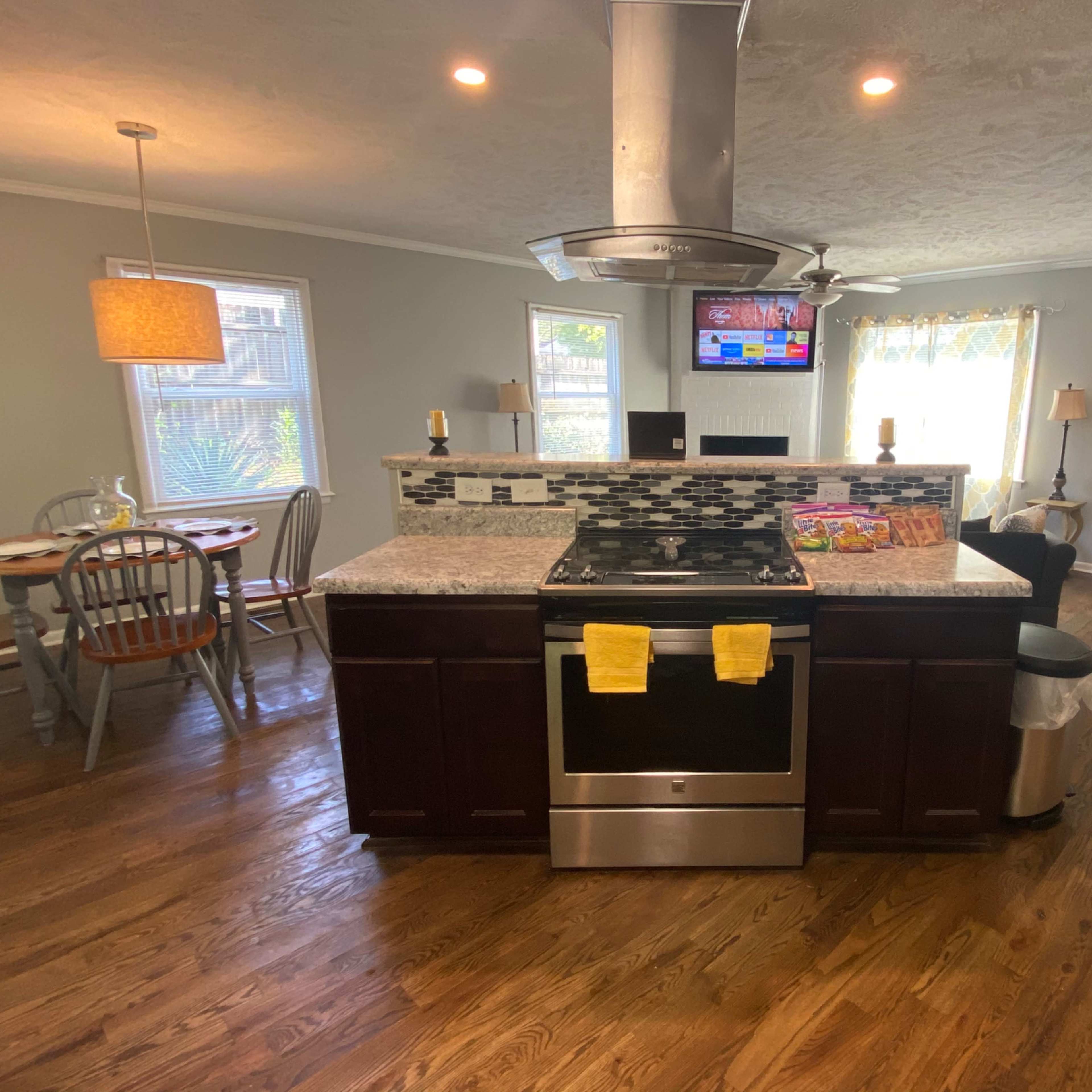 A modern kitchen with a central island, stainless steel appliances, and an adjacent dining area.