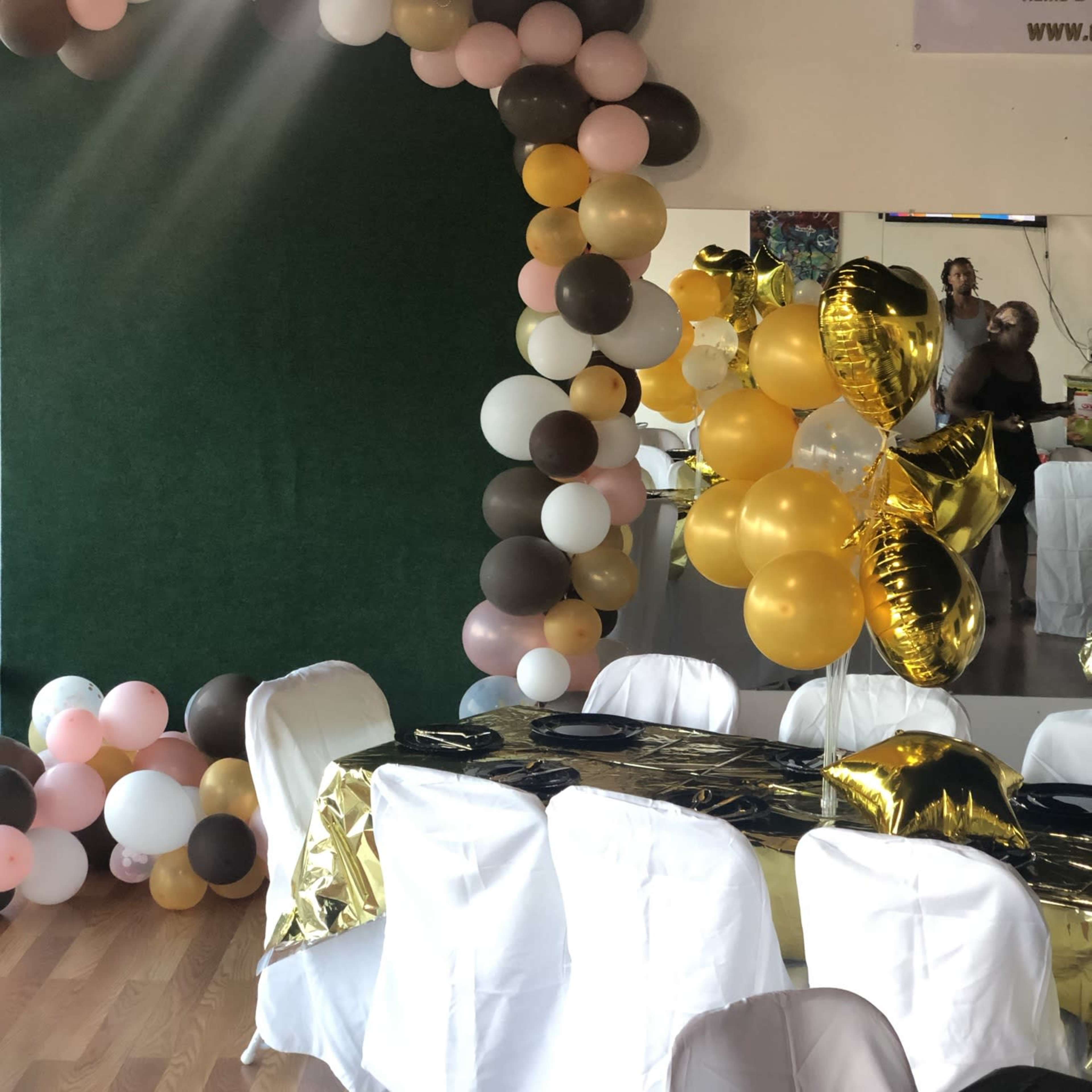 A banquet setup with tables covered in navy tablecloths, adorned with flower arrangements and place settings in a decorated room.