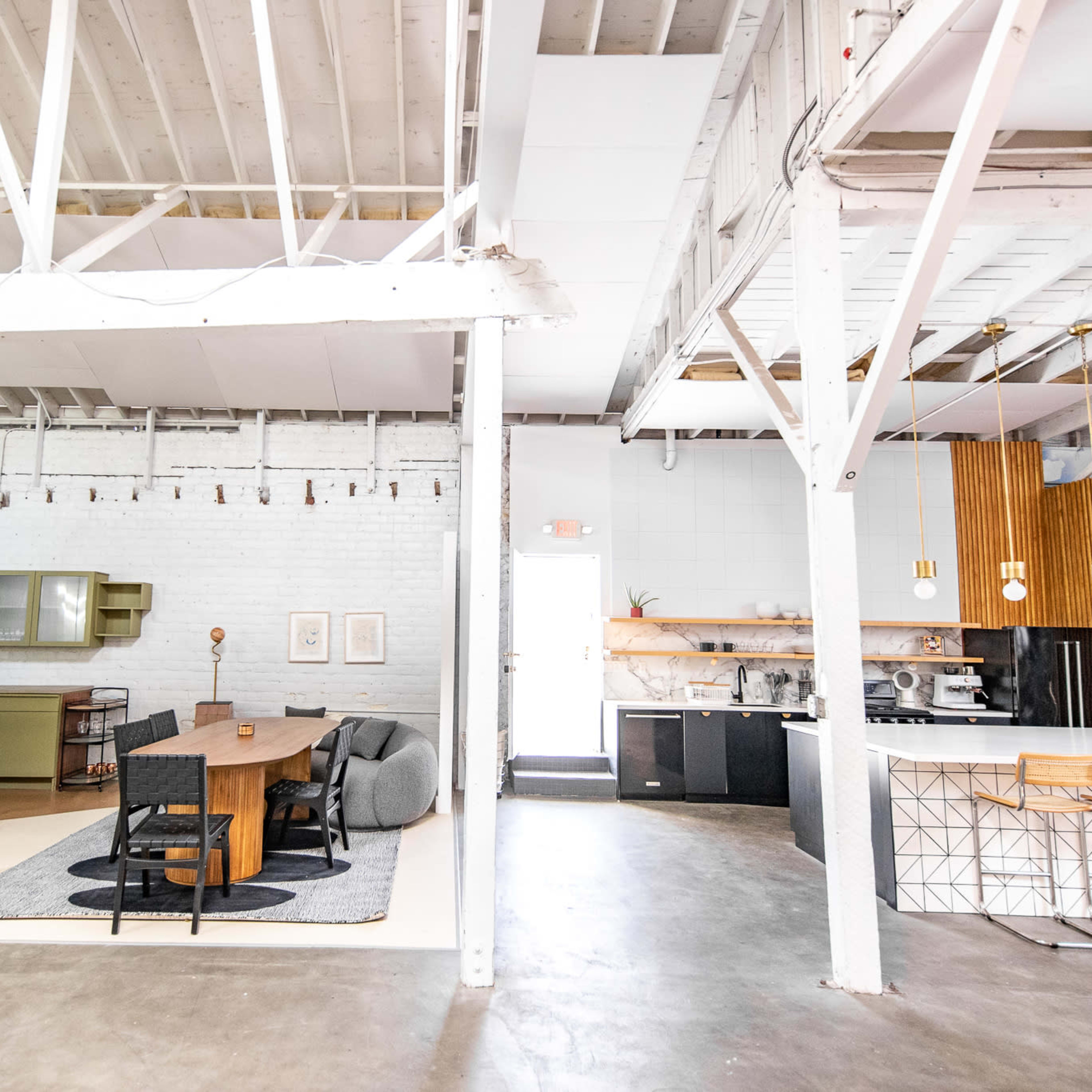 A spacious, open-concept kitchen and dining area with modern finishes and a combination of brick and wood elements.