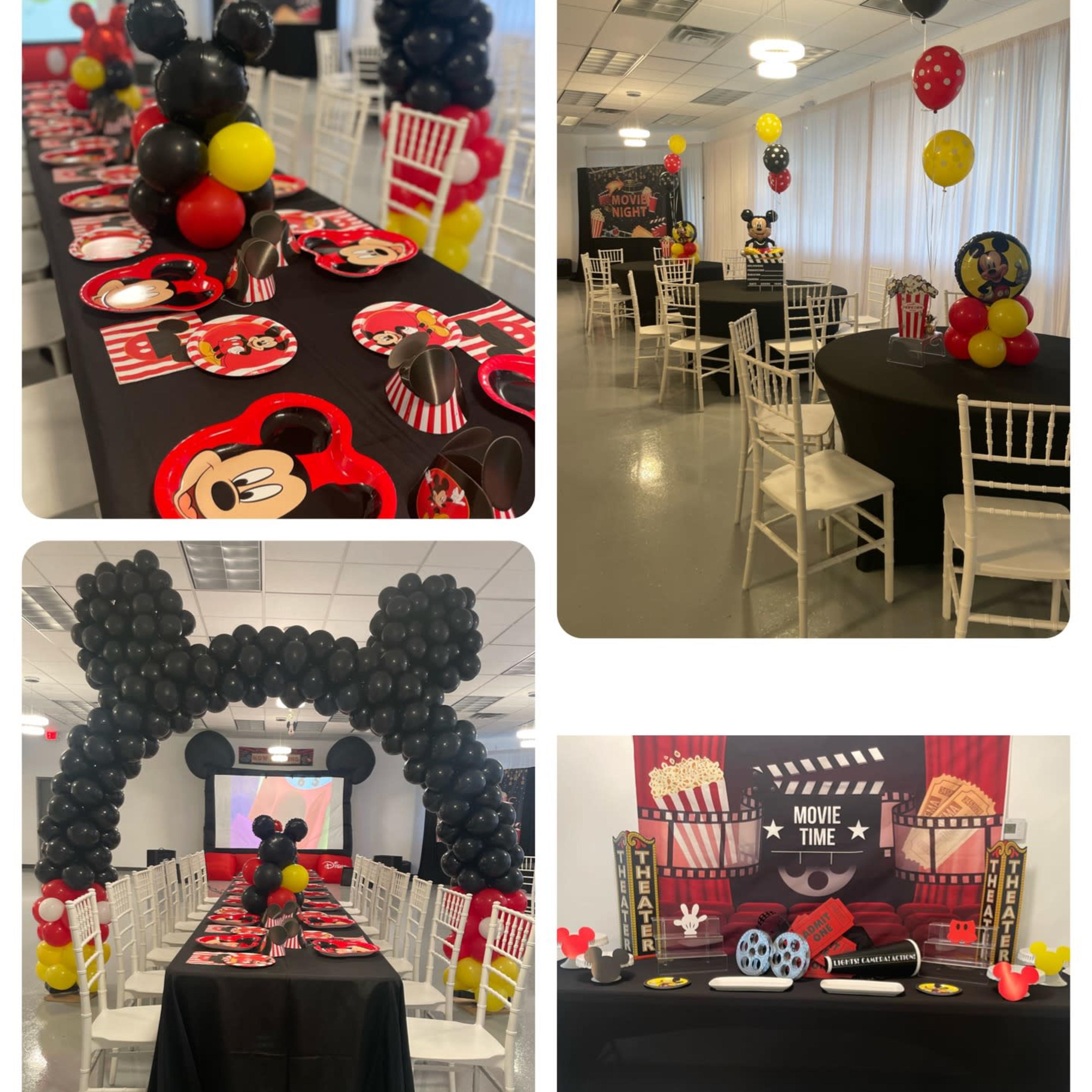 A party setup with themed tables, black and red decorations, and balloon arches, all arranged for a children's movie-themed celebration.