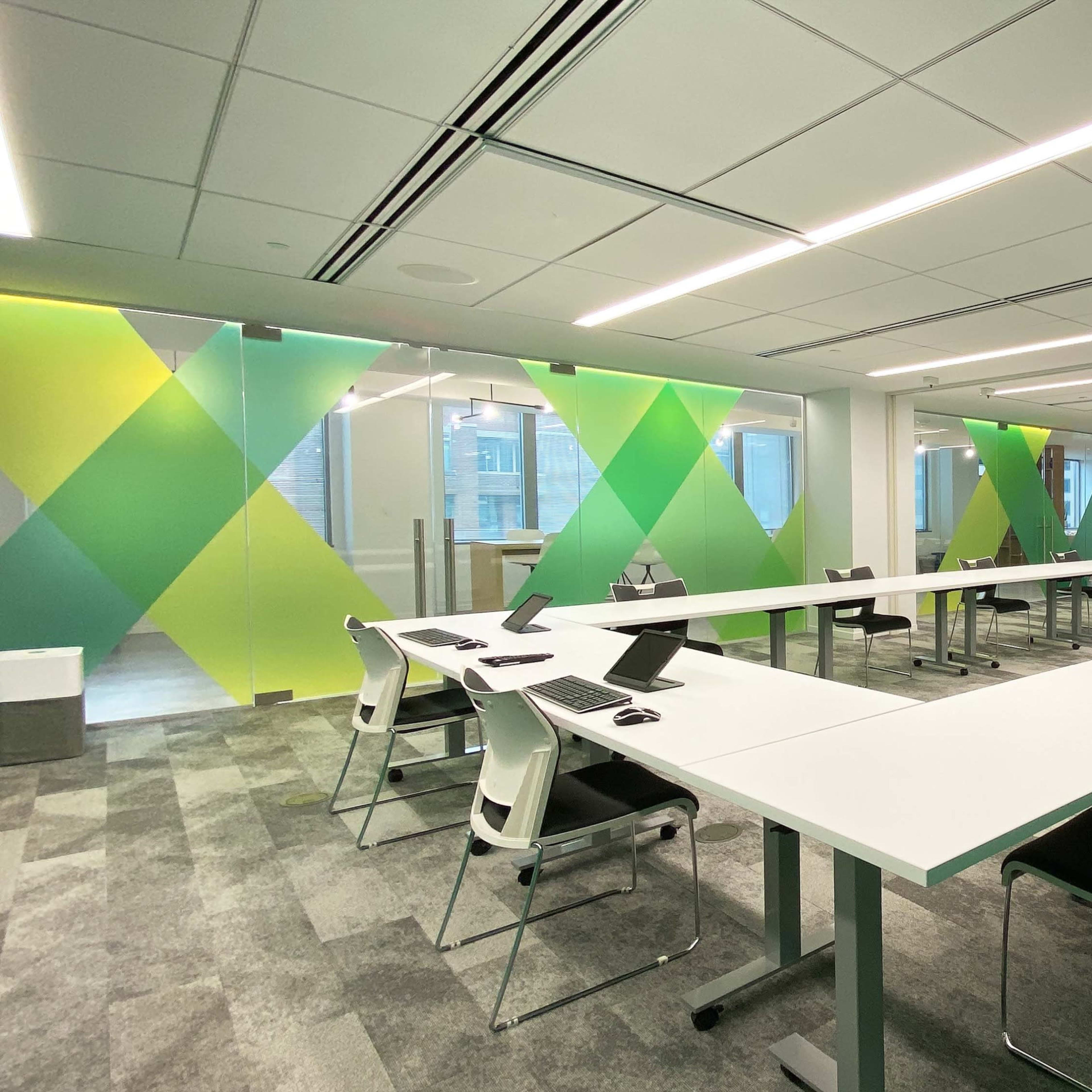 A modern conference room with a long table, chairs, and colorful green and yellow accent walls.