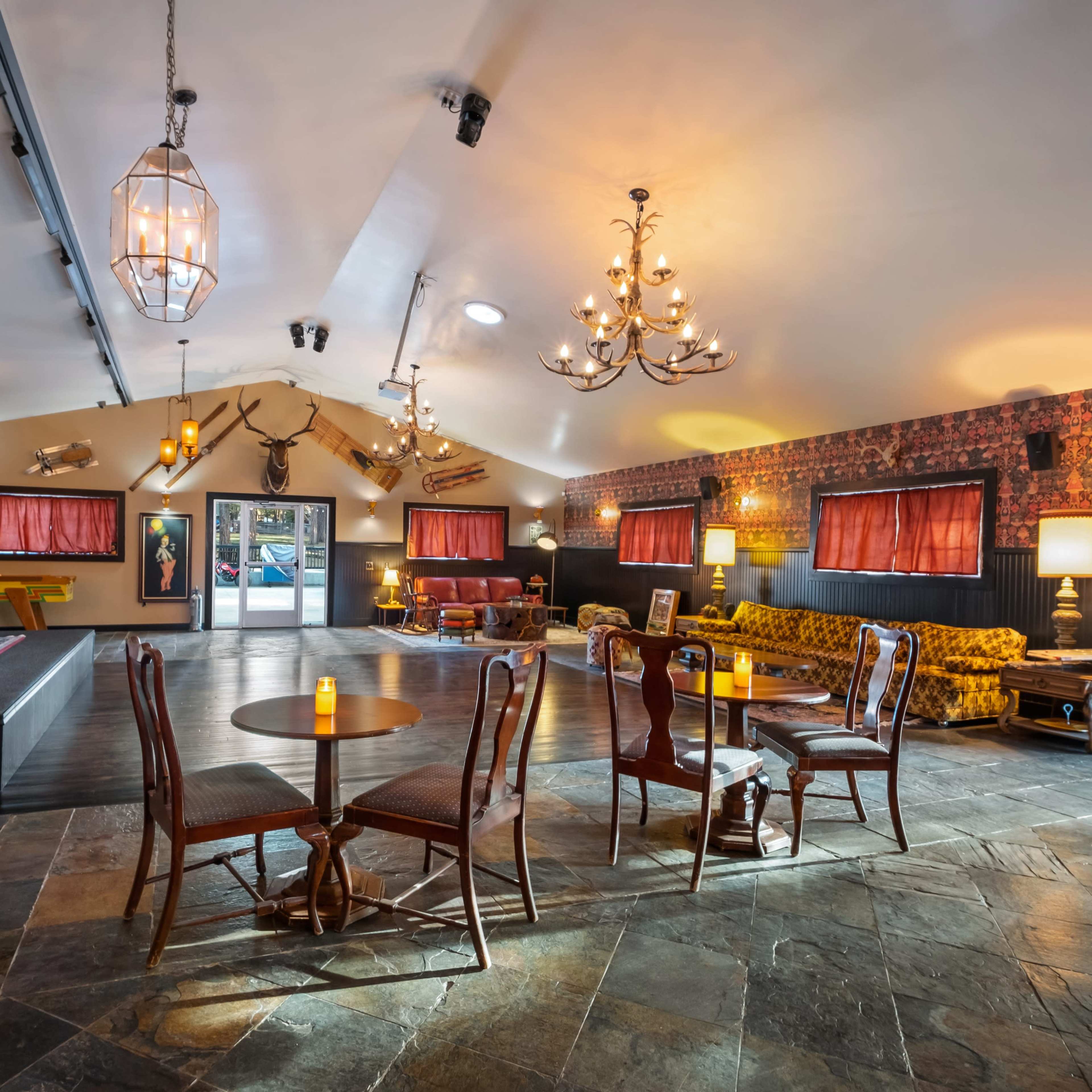 A spacious interior with a combination of seating areas, decorative lighting, and patterned walls.