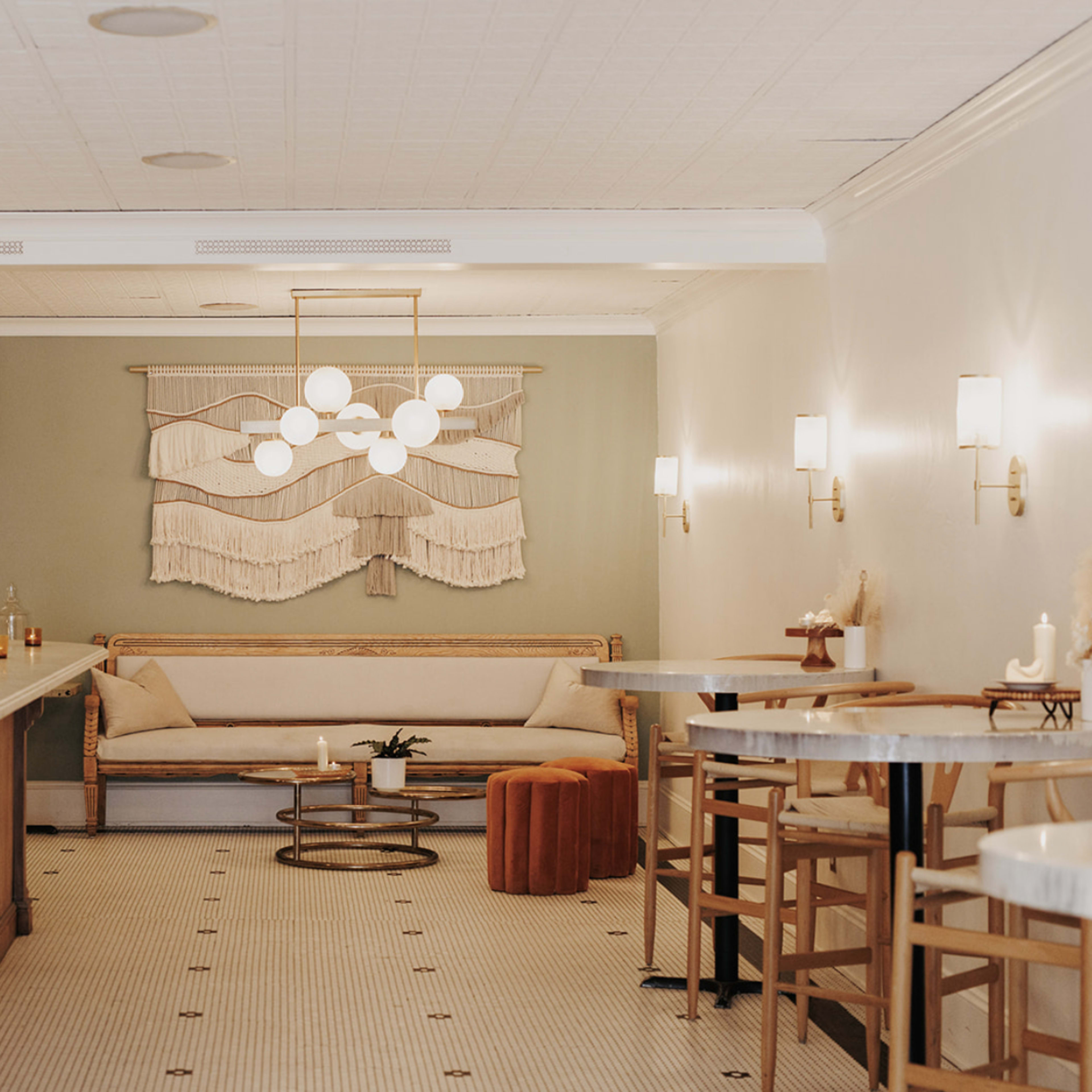 A minimalist interior of a cafe or lounge with a marble bar, wooden seating, and decorative wall art.