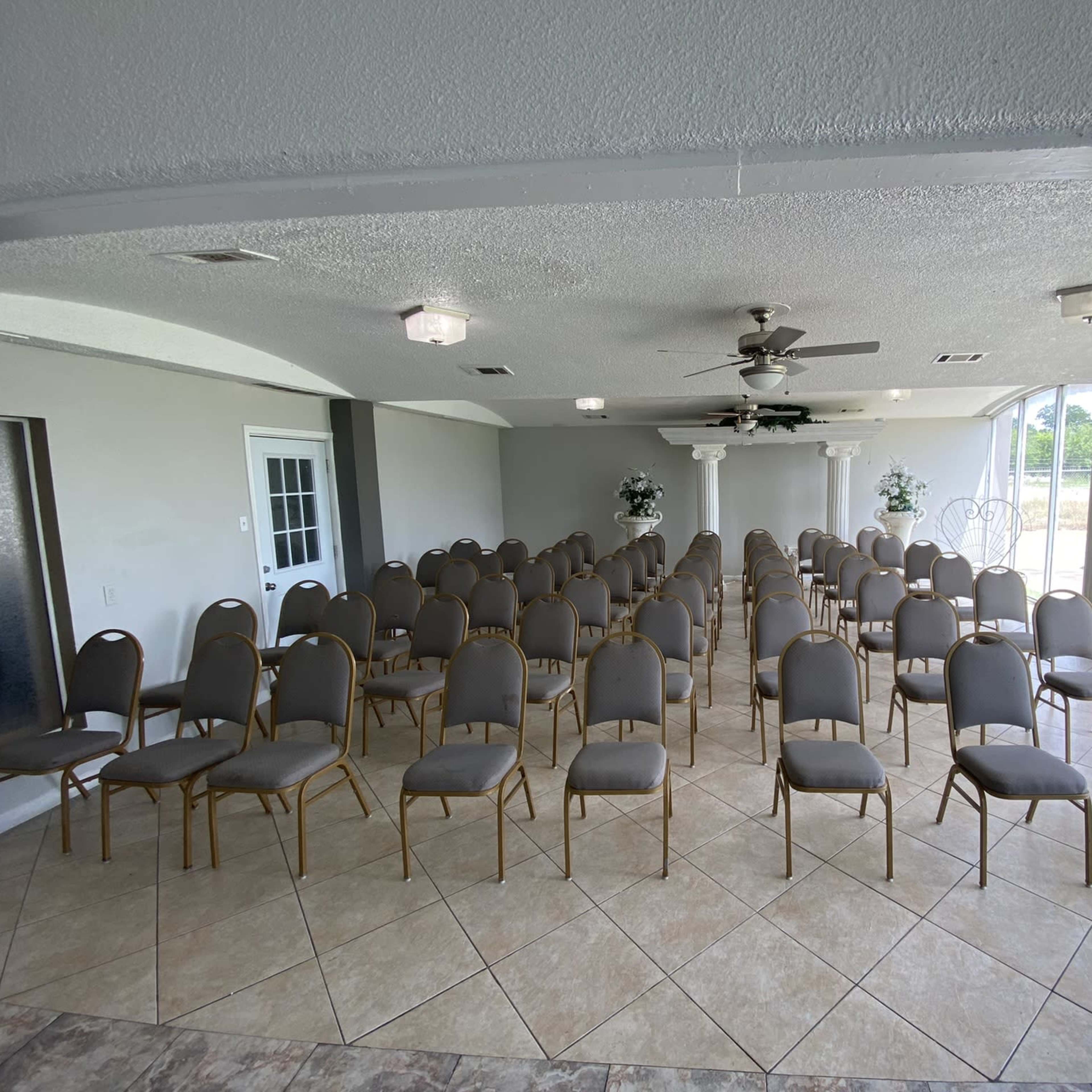 A spacious indoor venue set up with rows of empty chairs arranged for an event.