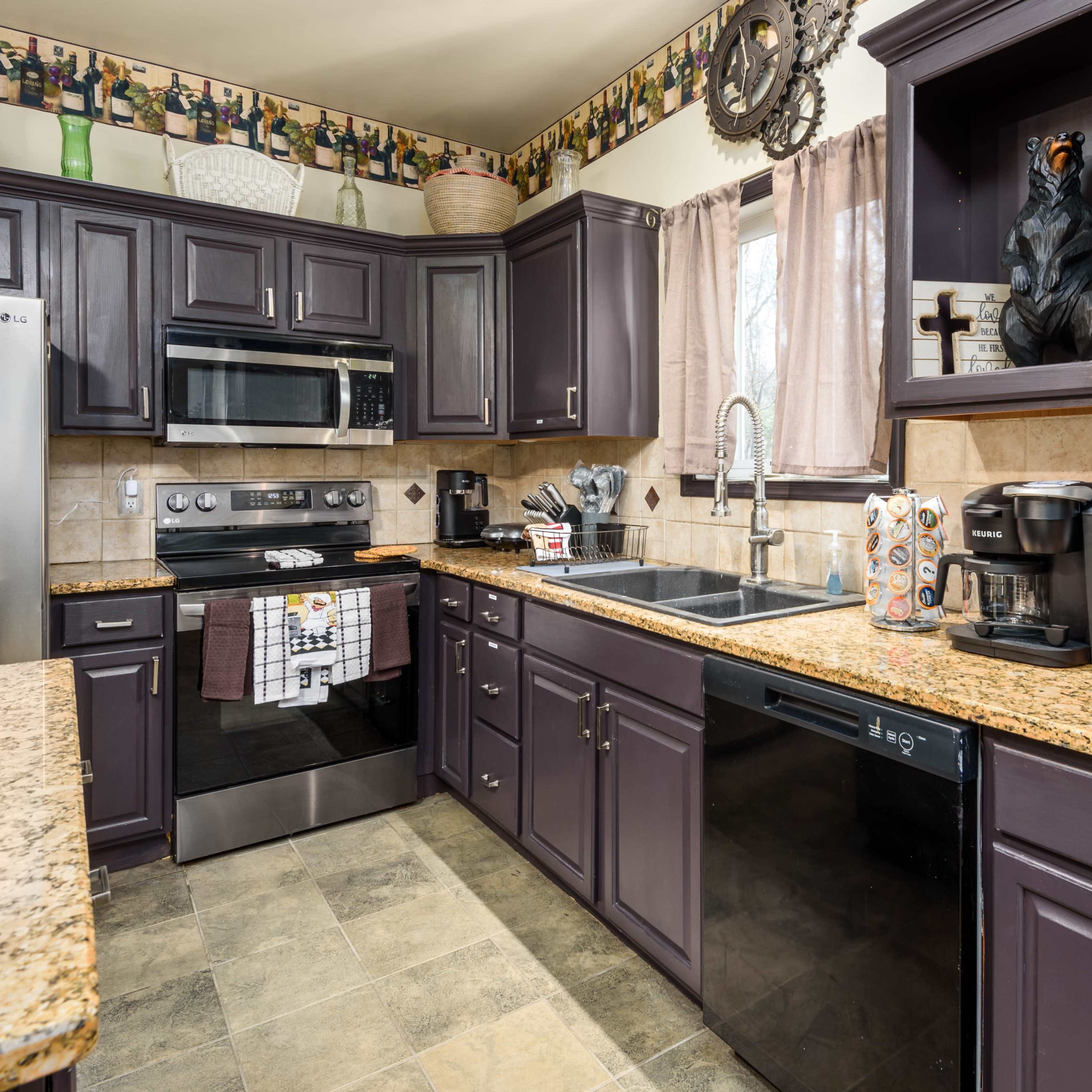 A modern kitchen features dark cabinetry, stainless steel appliances, and granite countertops, with decorative items and coffee mugs displayed.