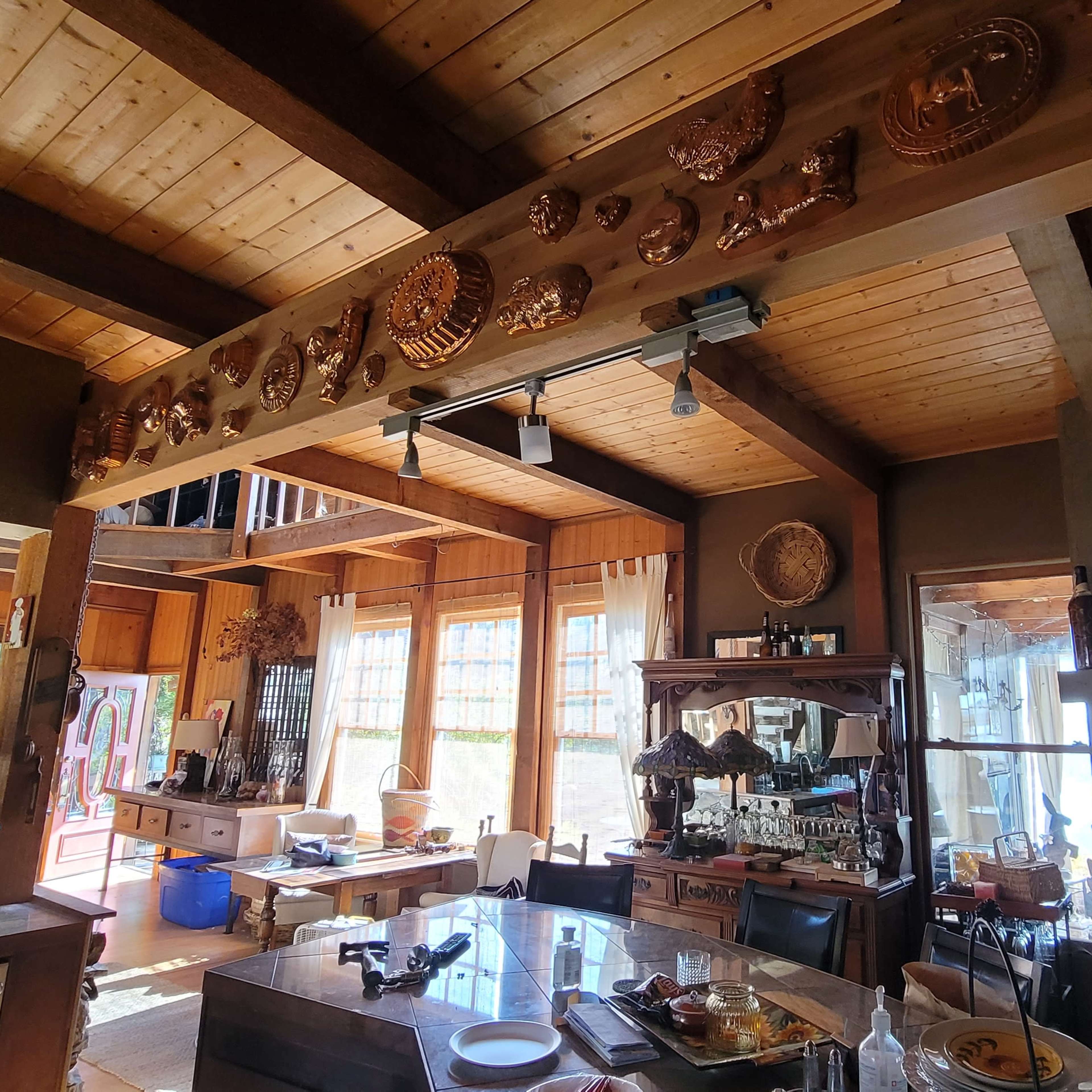 A cozy interior room with wooden beams, a fireplace, and various decorative items on display.