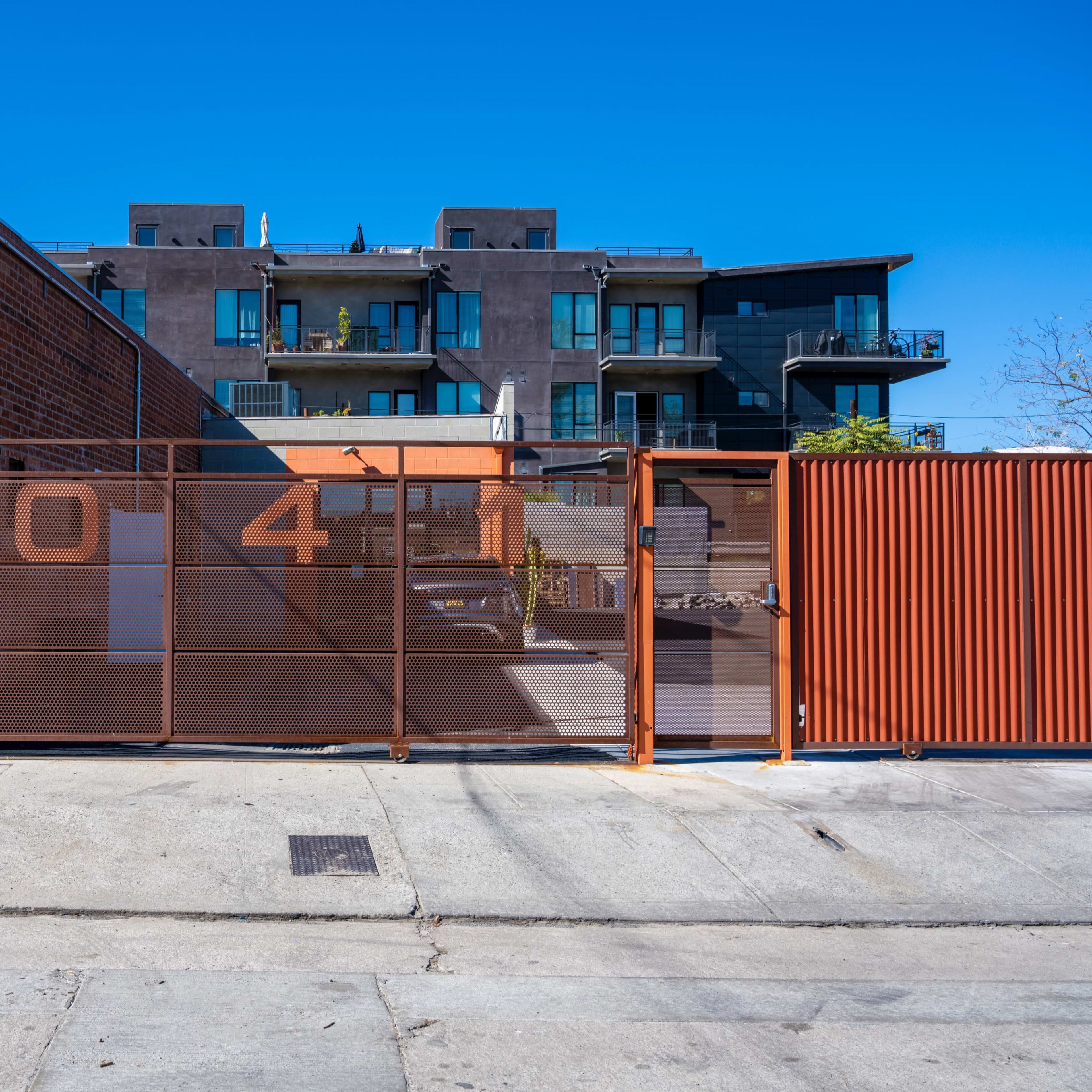 A fenced area with the number "304" prominently displayed, adjacent to a multi-story building with balconies.