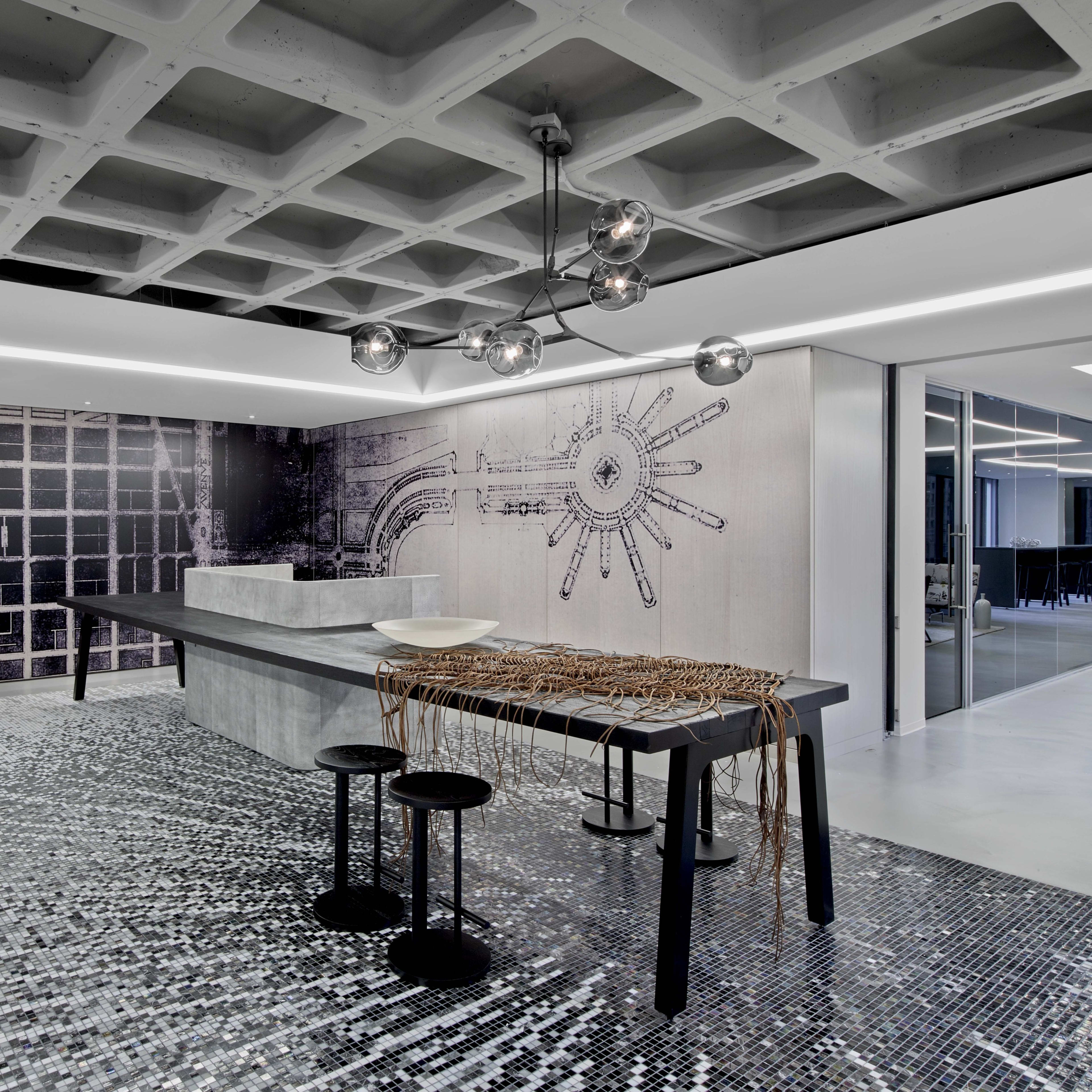 A modern interior space featuring a textured ceiling, a large, minimalist kitchen island, and a stylish mosaic floor, complemented by contemporary lighting fixtures.