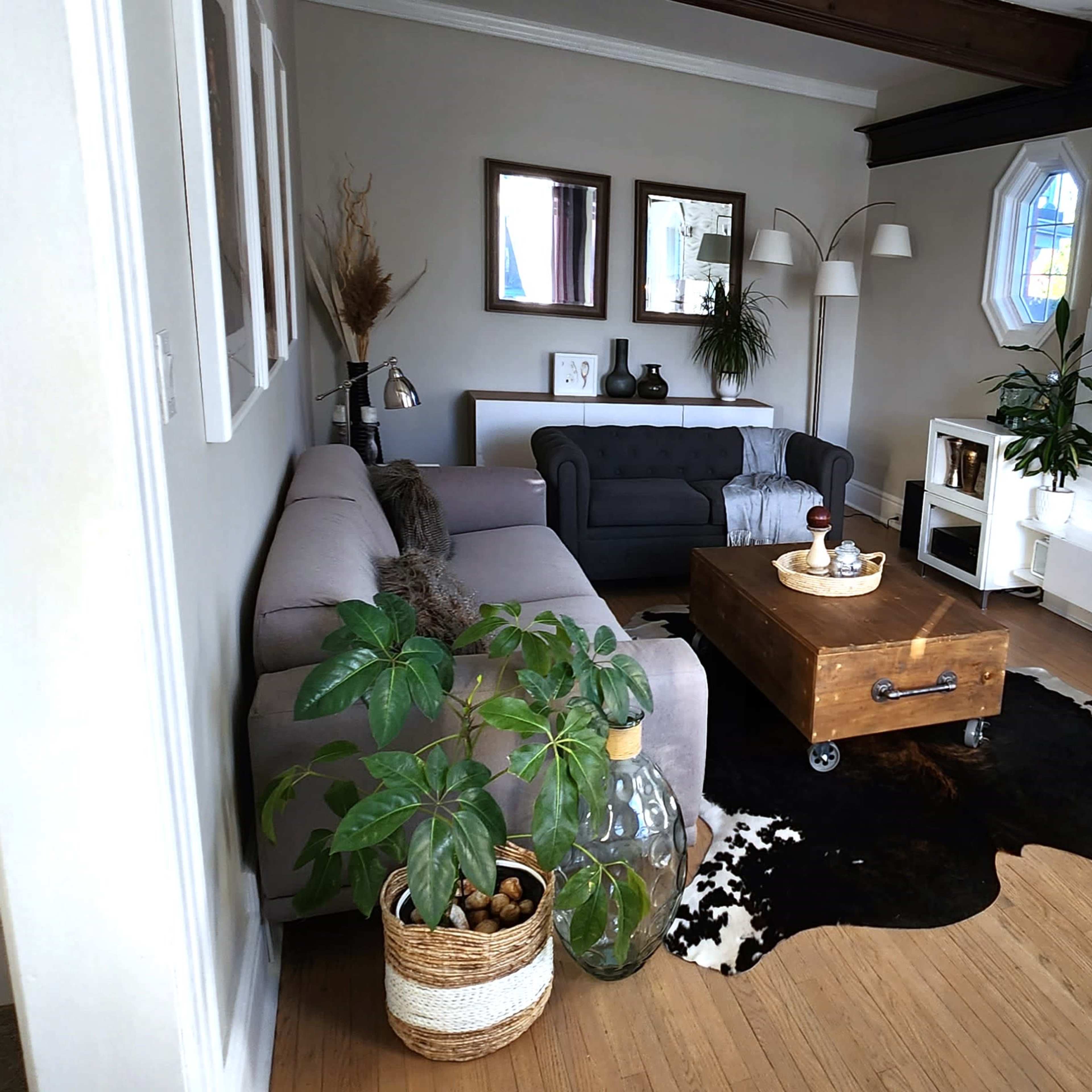 A modern living room with a sectional sofa, a wooden coffee table, decorative vases, and a stylish wall featuring a fireplace and a textured design.