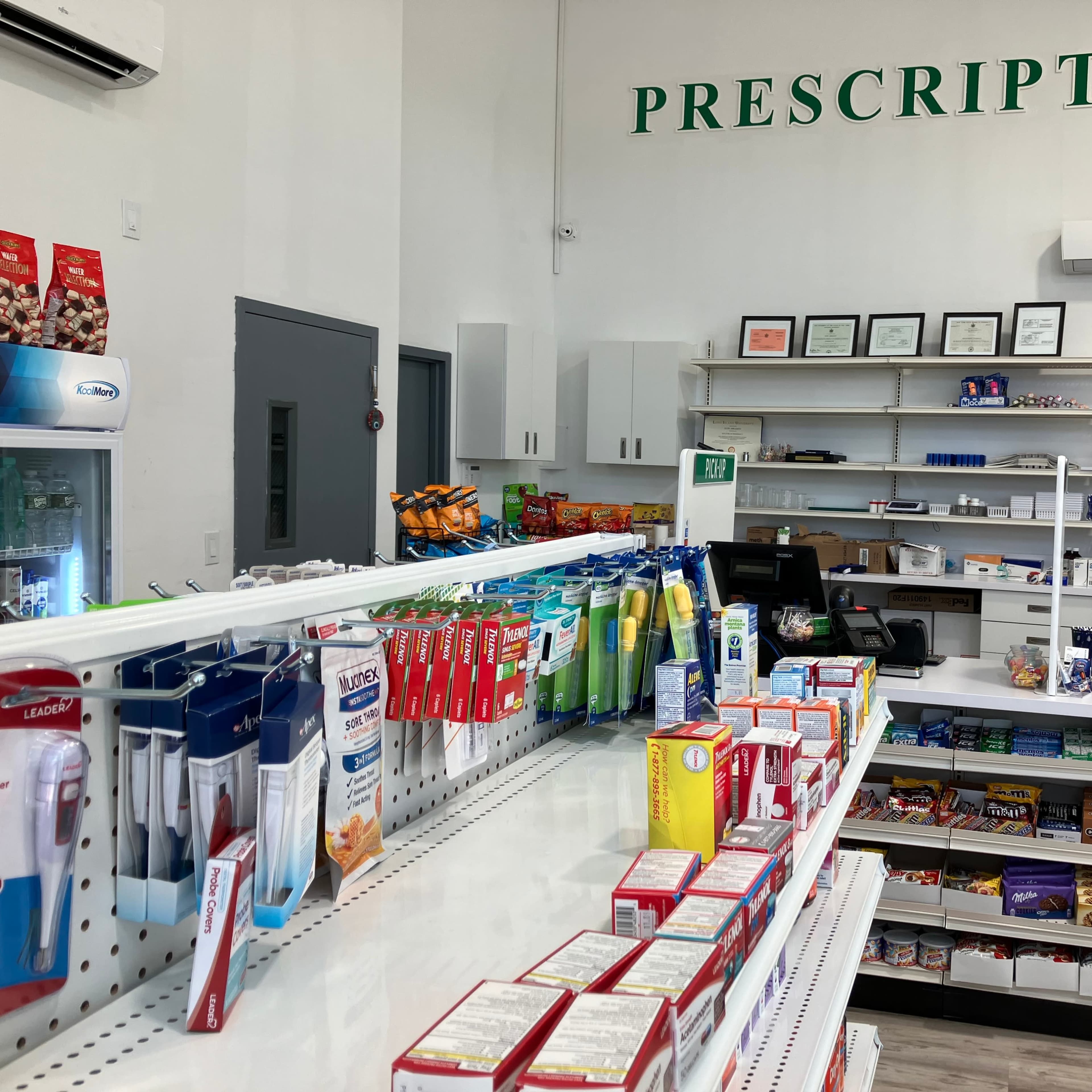 An interior view of a pharmacy with a focus on the prescription area, featuring organized shelves stocked with various health products and snacks.