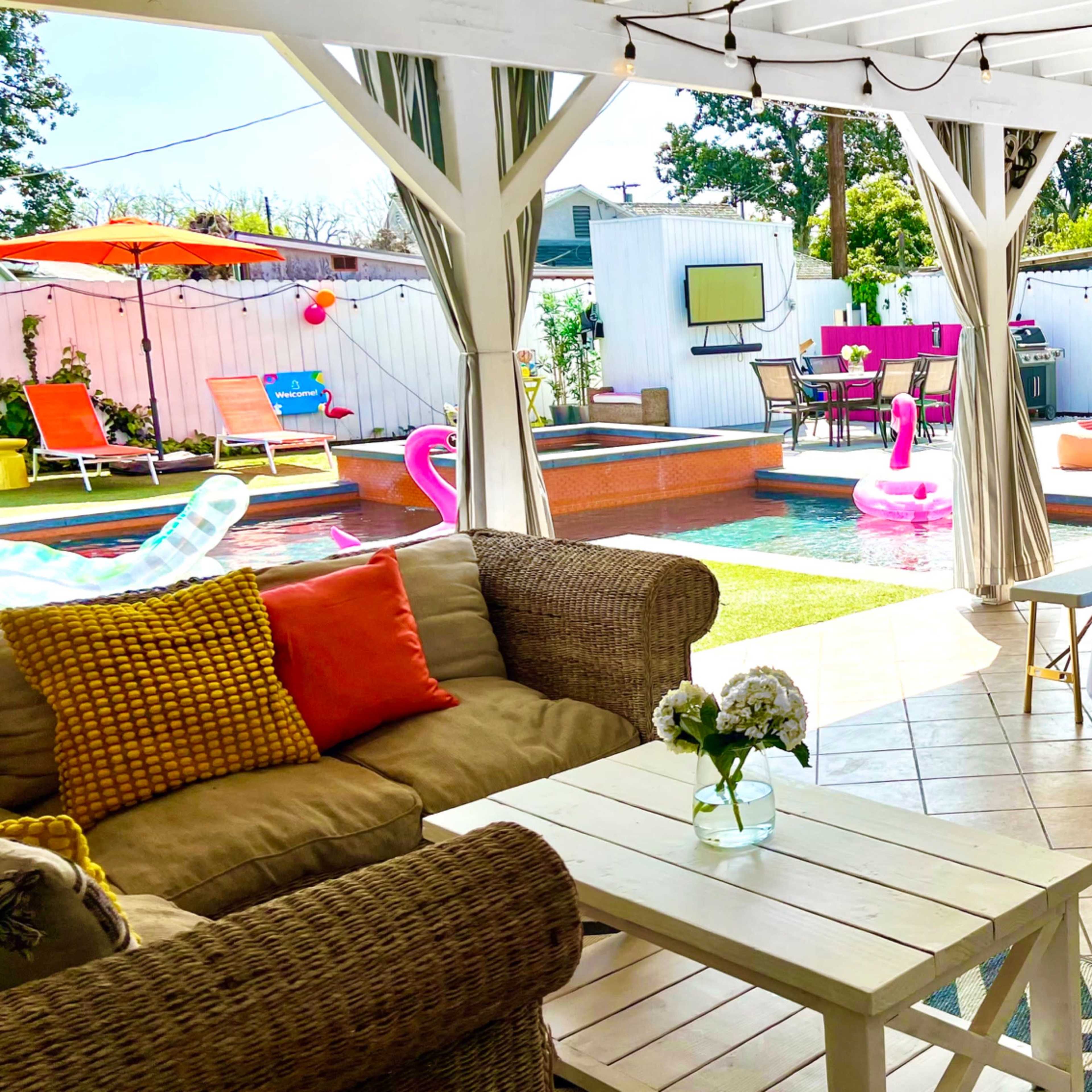 A spacious outdoor patio area with a pool, lounge seating, and festive decorations.