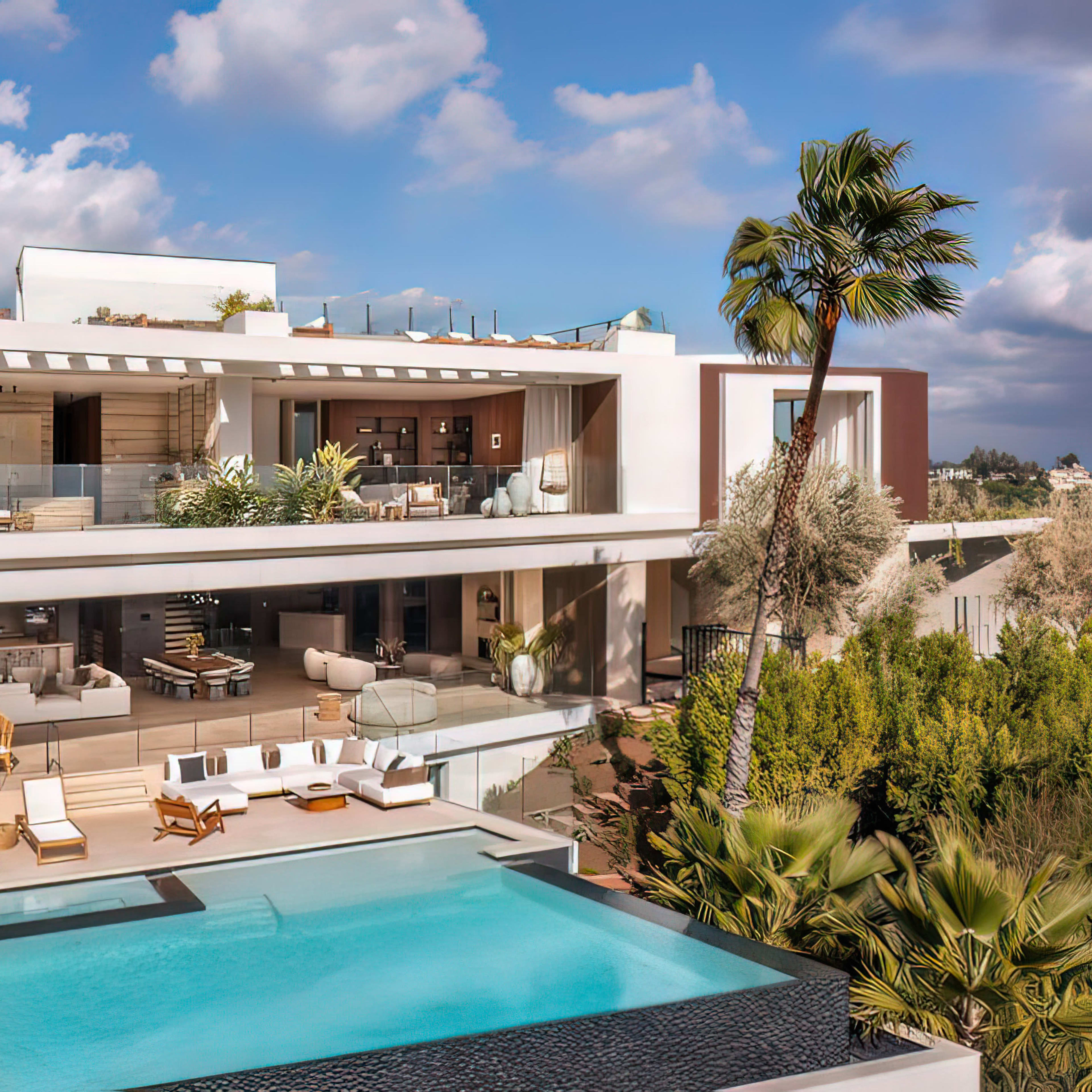 A modern two-story villa with a swimming pool and patio area is surrounded by greenery and features large windows that showcase the interior.
