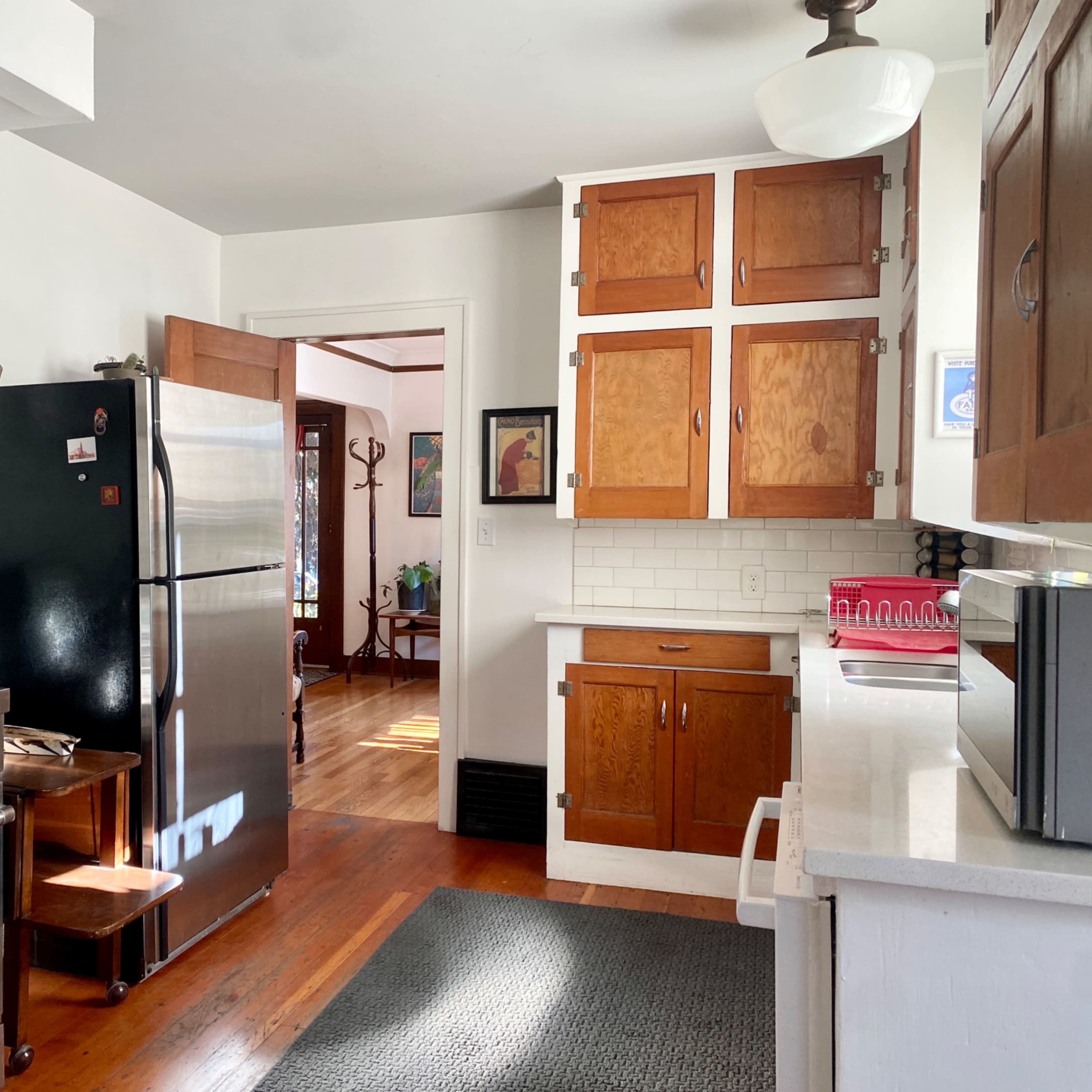 A clean kitchen features stainless steel appliances, wooden cabinets, and a tile backsplash.
