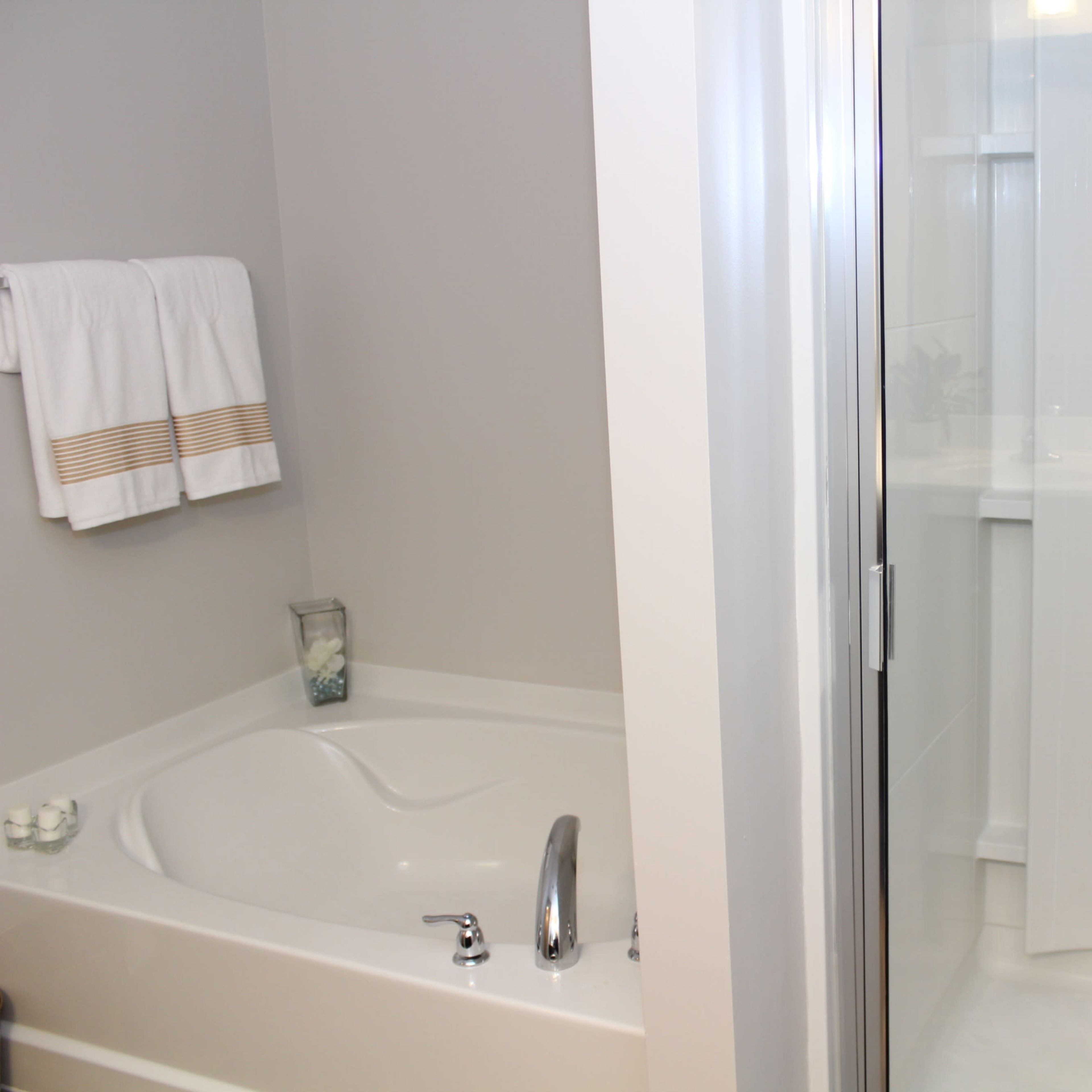 A bathroom featuring a bathtub on the left and a glass shower enclosure on the right.