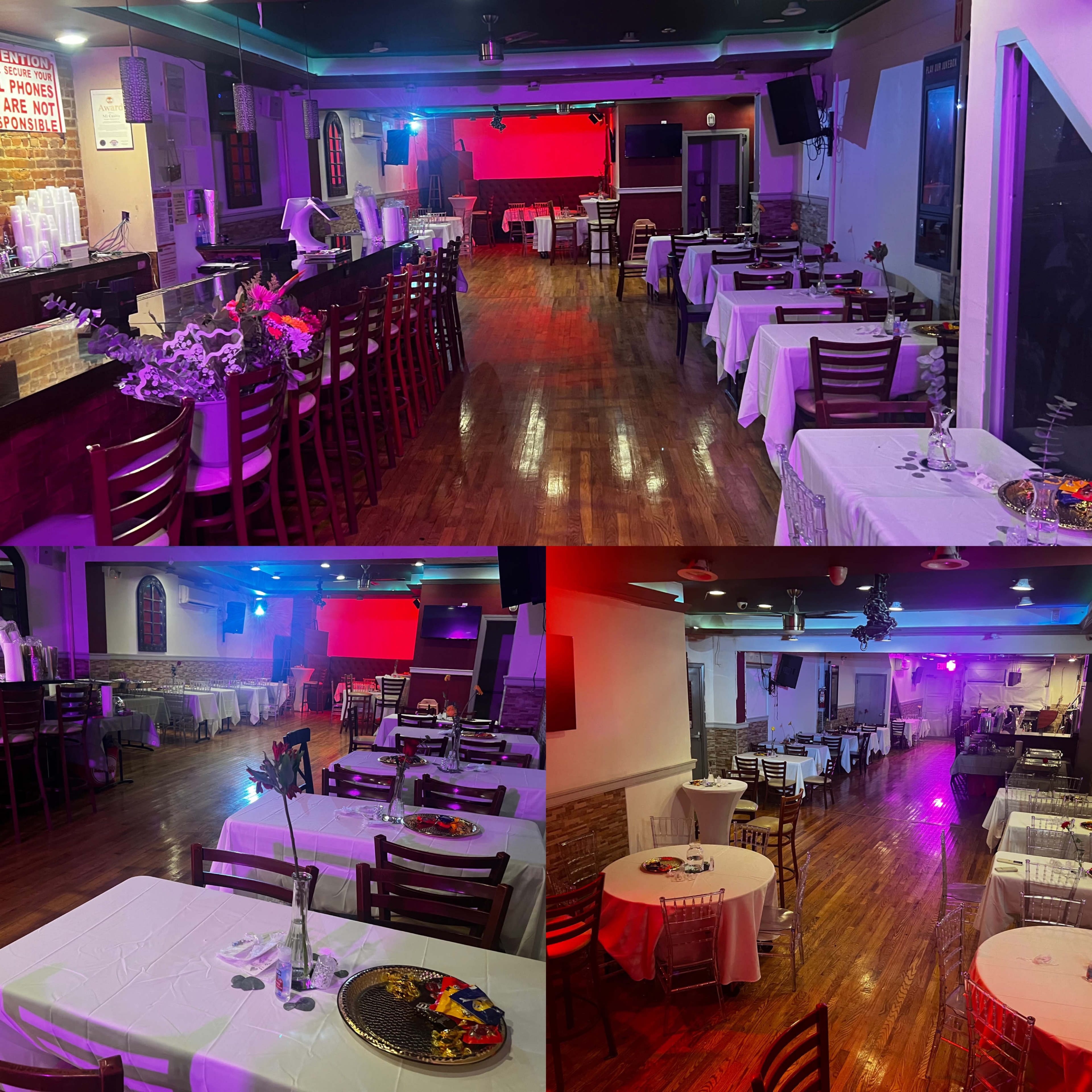 A spacious restaurant interior with multiple tables covered in white tablecloths and wooden chairs, illuminated by colorful lighting.
