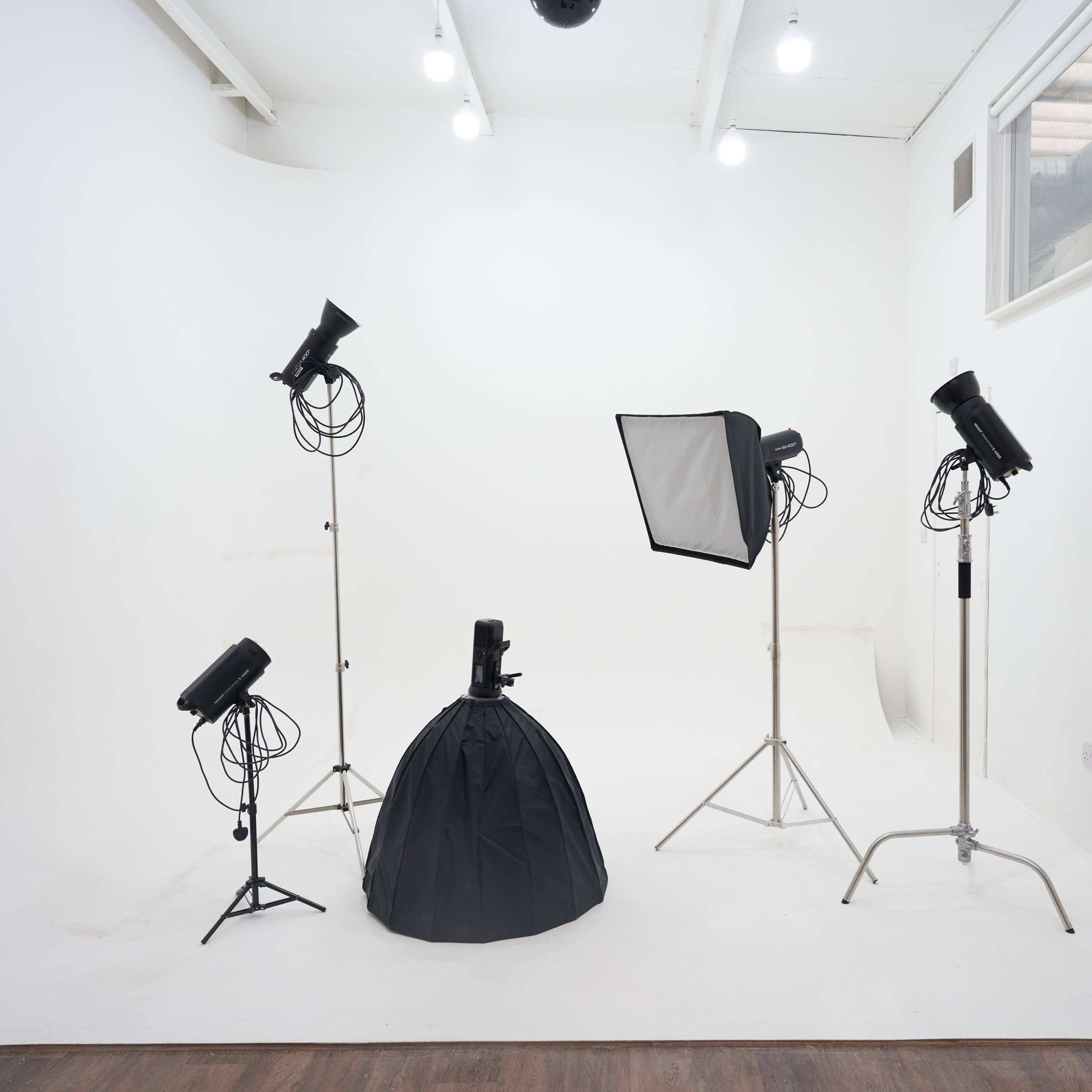A photography studio with lighting equipment positioned around a black backdrop.