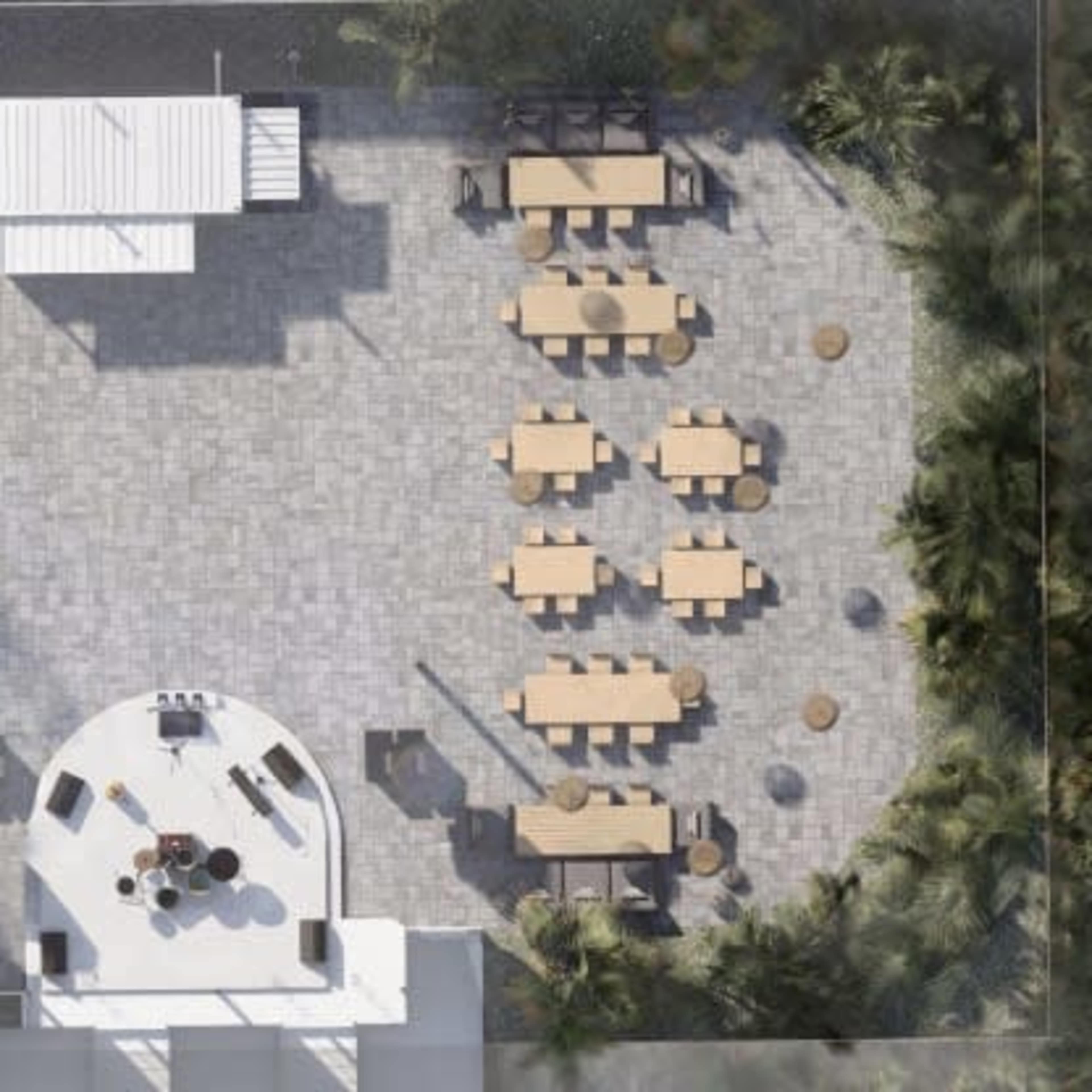 An aerial view of a patio area featuring various seating arrangements, tables, and landscape elements.