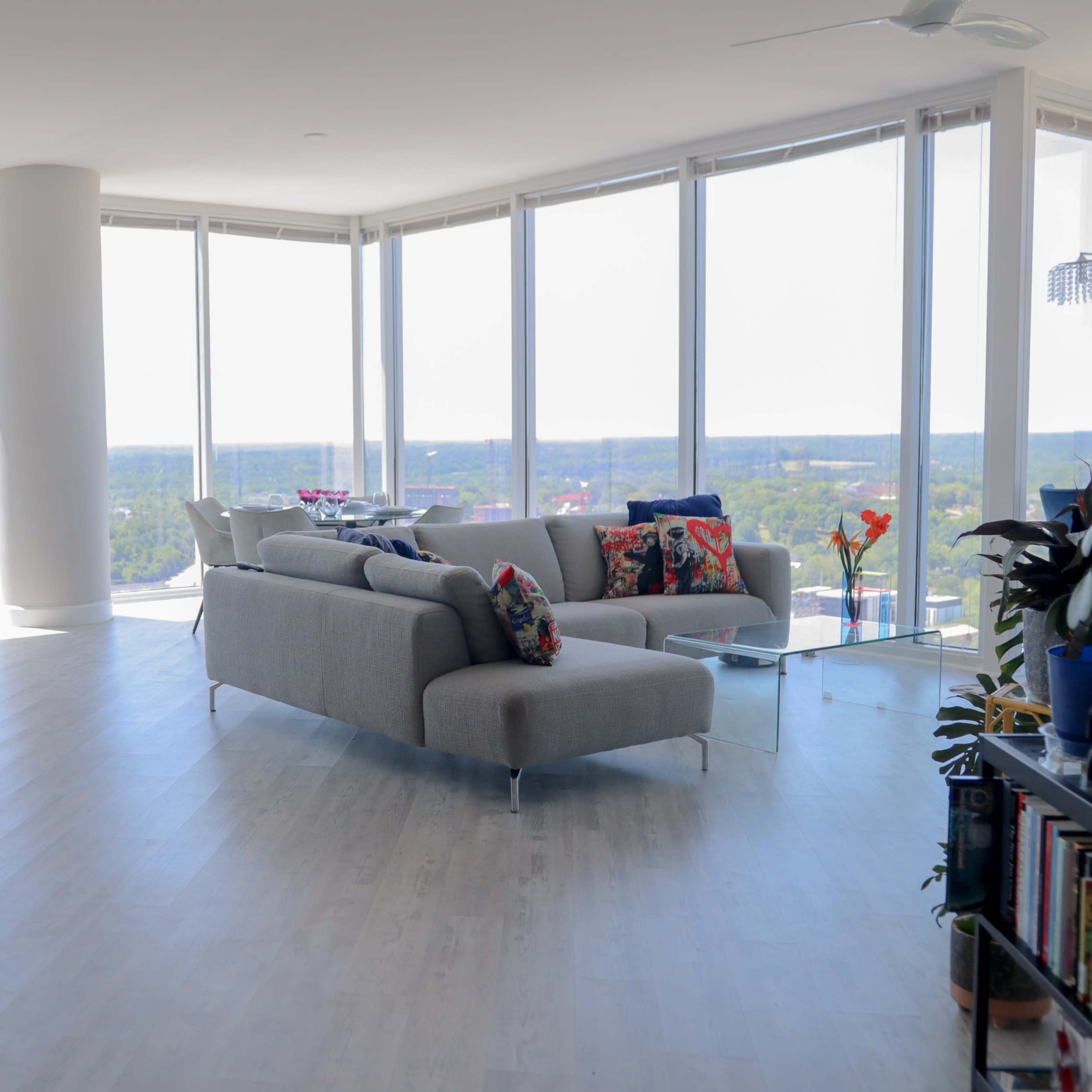 A modern, open-concept living area with large windows that provide a view of the skyline and cityscape.