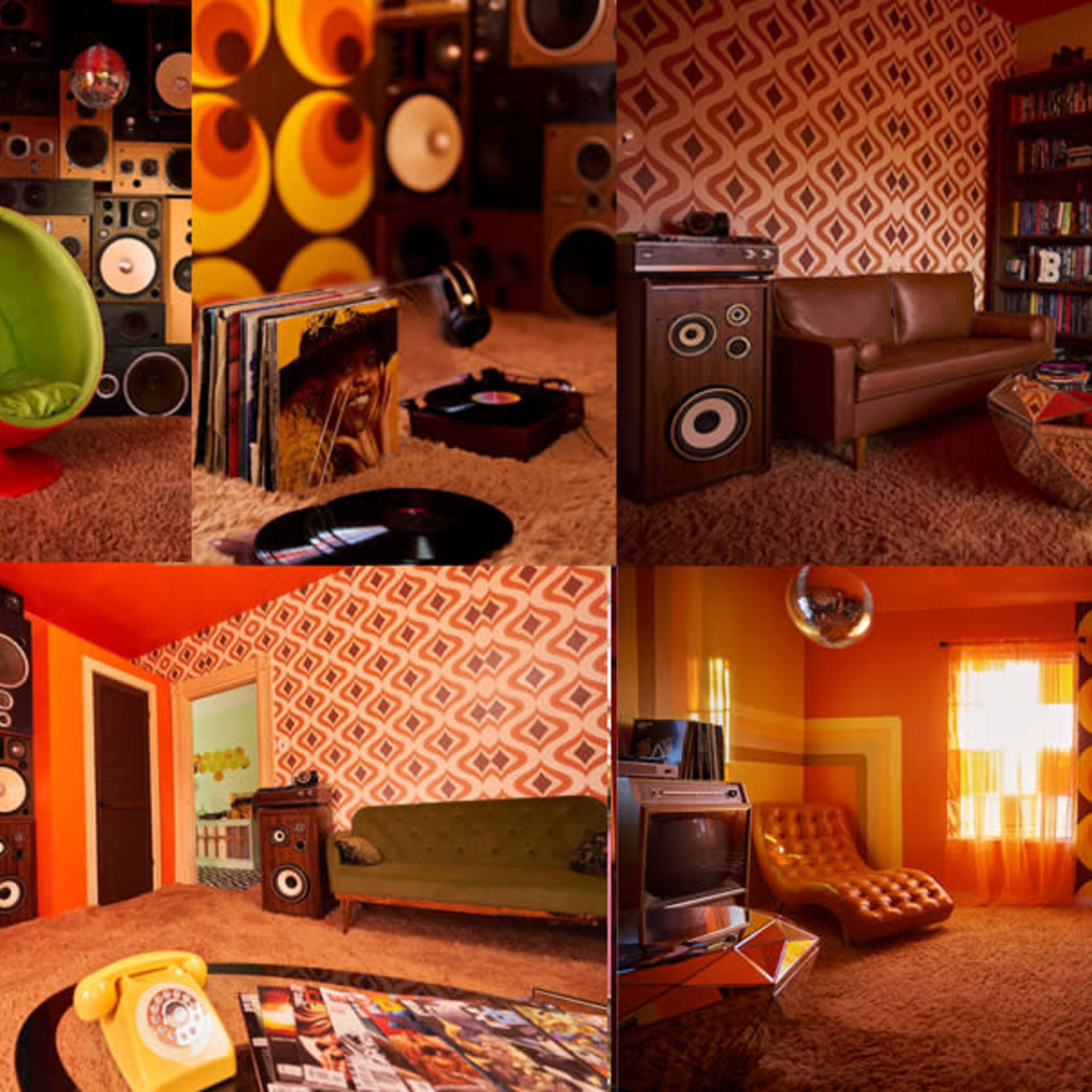 A retro-styled room with vibrant orange walls, circular decor, a green chair, a vintage TV, and an array of audio speakers.
