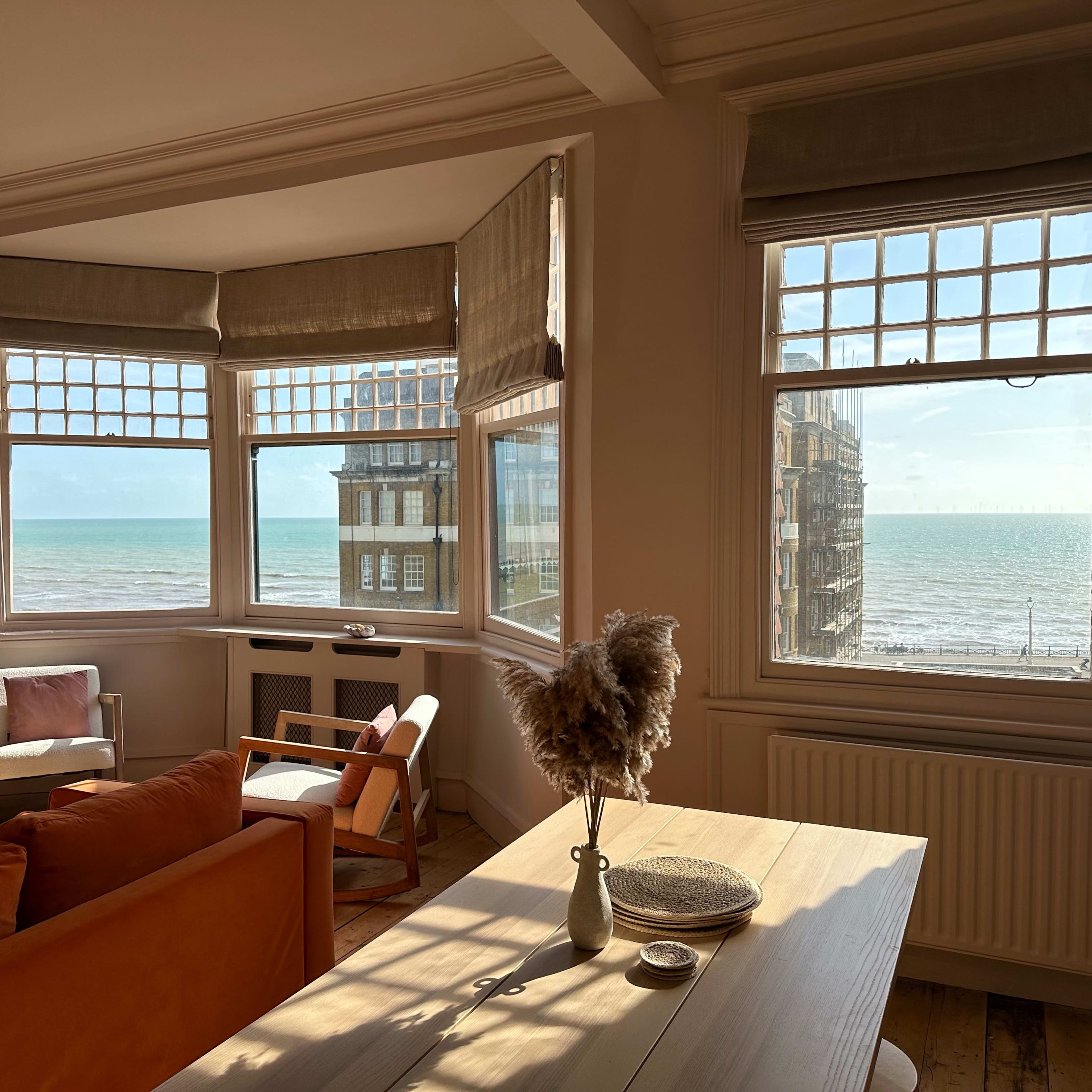 A bright living room with large windows overlooking the ocean.