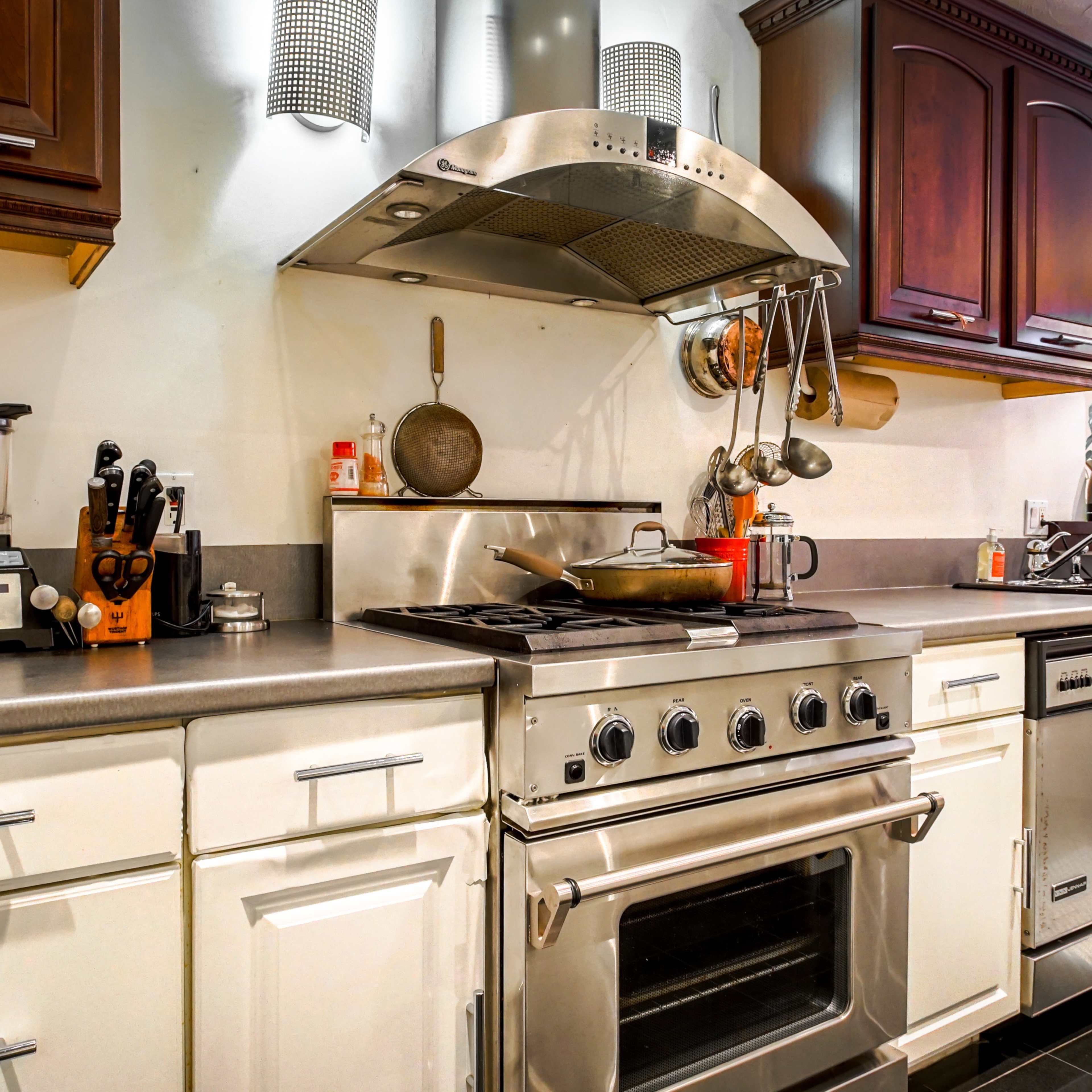 A modern kitchen with stainless steel appliances, a gas stove, and wooden cabinets.