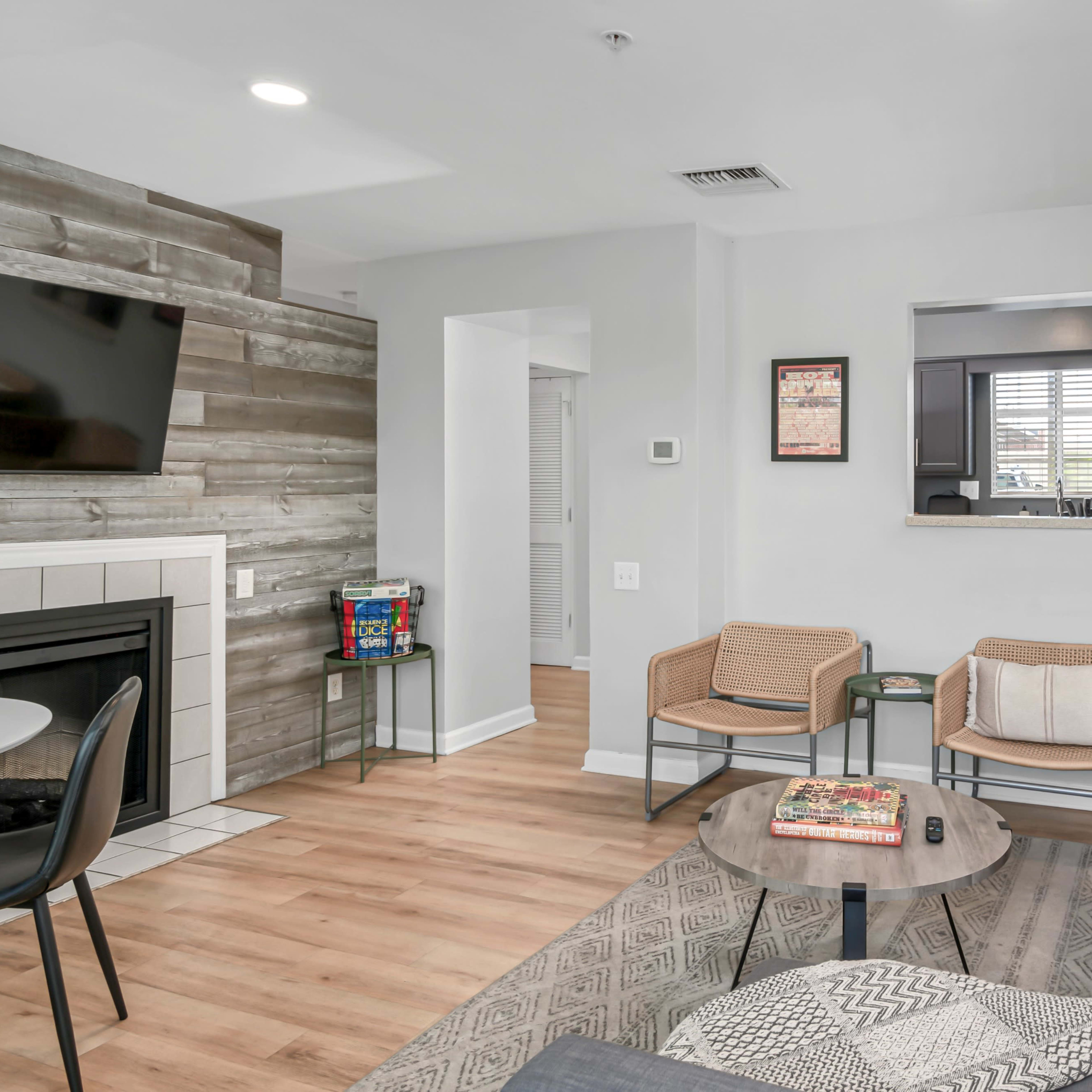 The living room features a gray sofa, a wooden coffee table, a fireplace, and a media unit with a television.