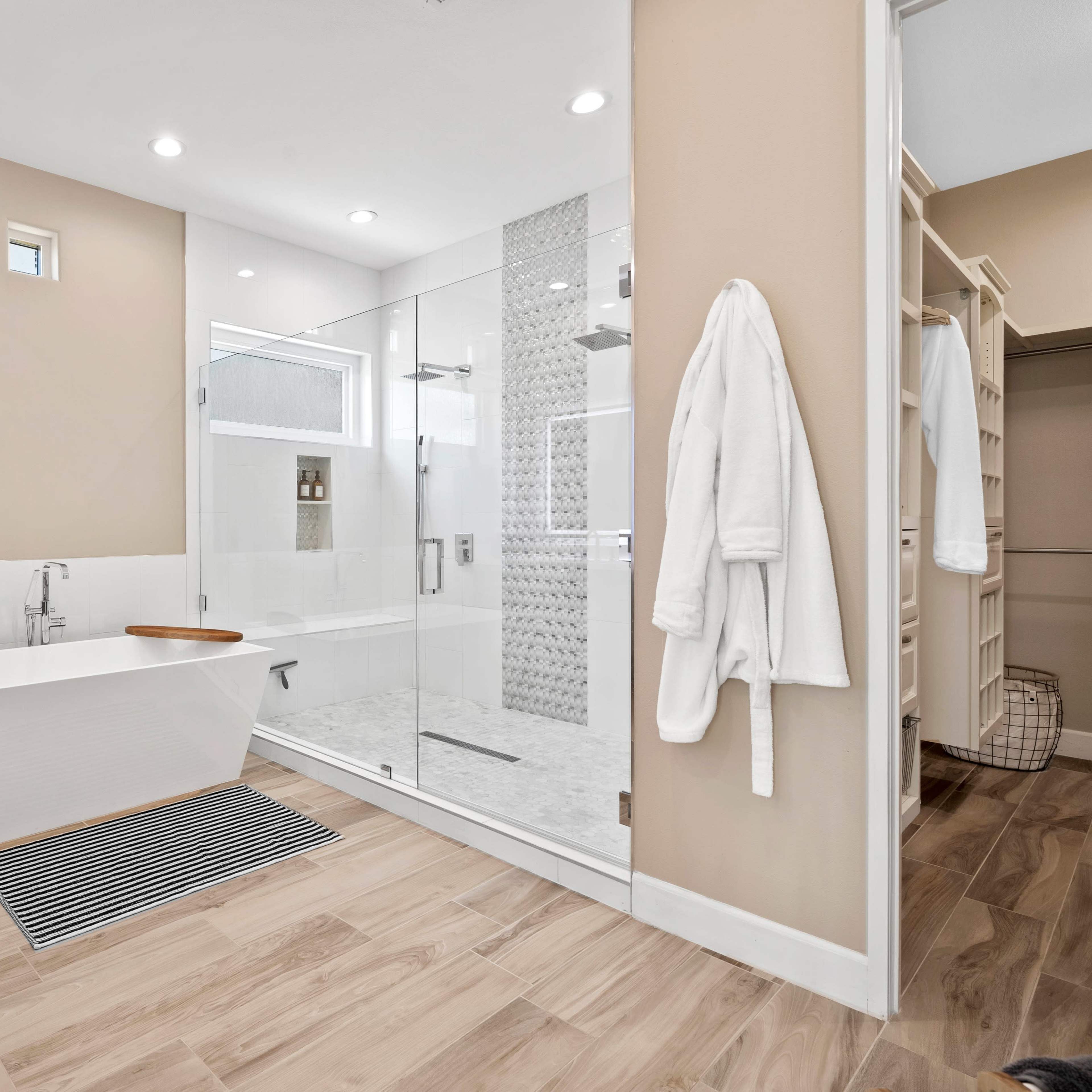A modern bathroom featuring a freestanding bathtub, a glass-enclosed shower, and a spacious vanity area.
