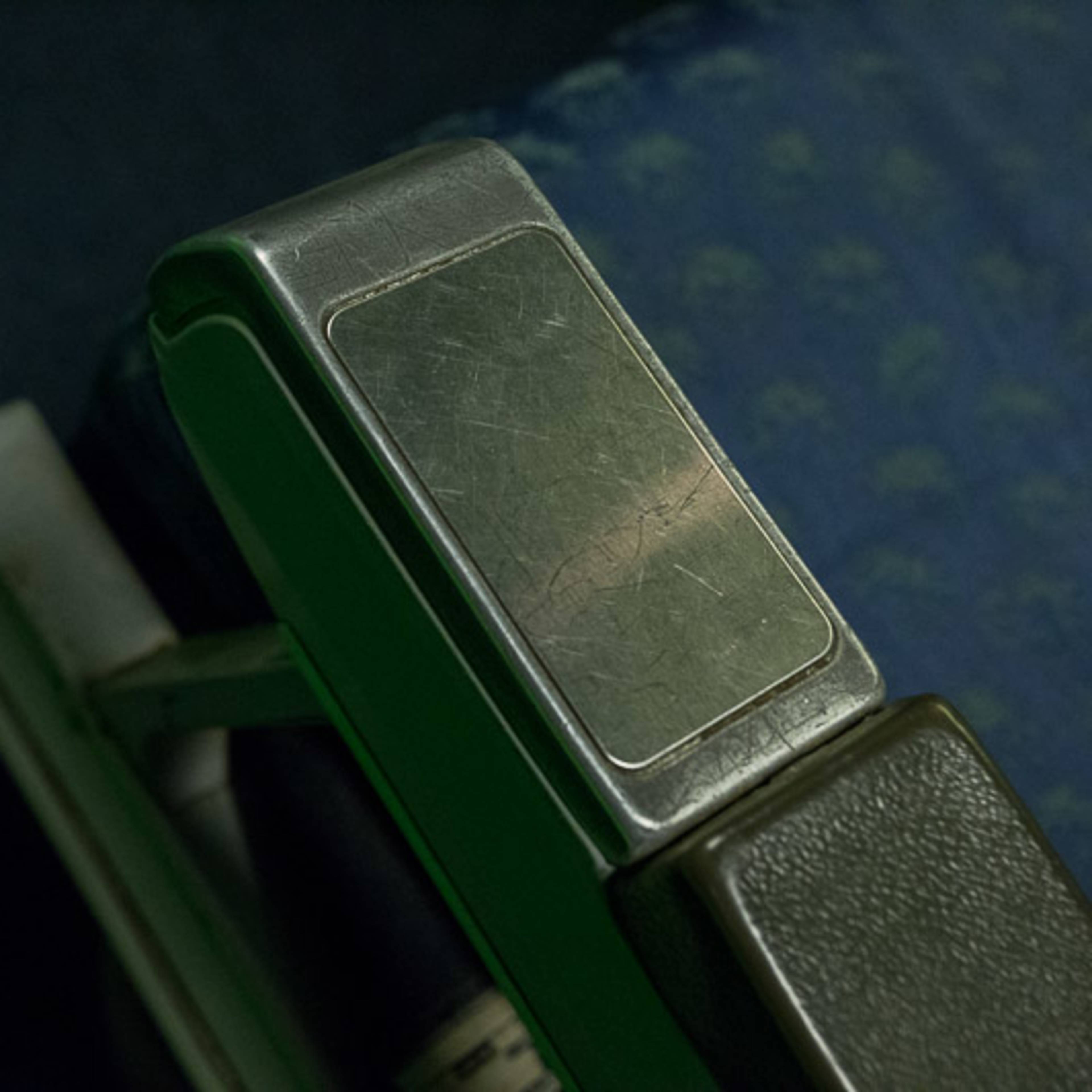 A metallic stapler positioned on a dark blue surface with a patterned texture.