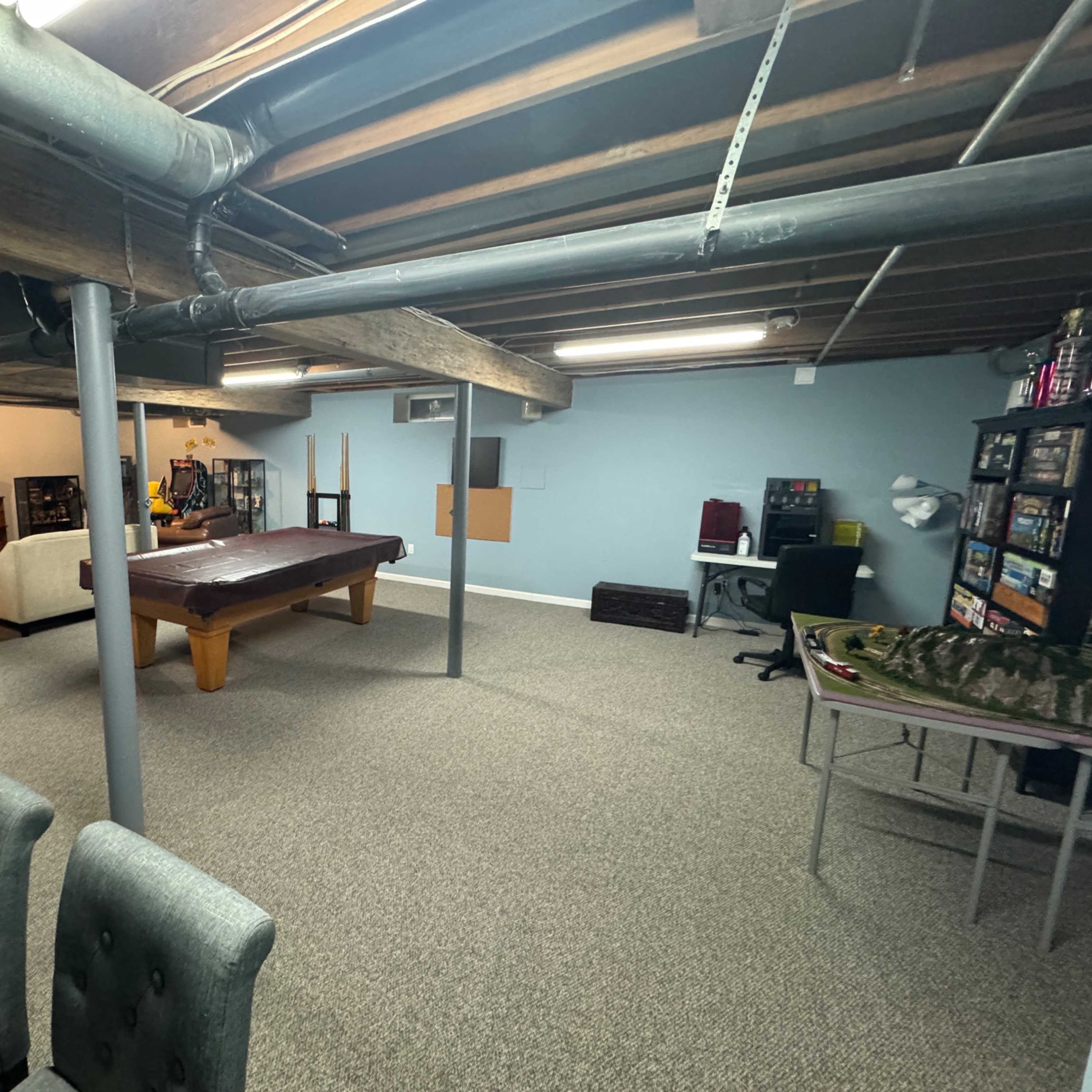Finished basement with entertainment and table area with chair for computer work. Image in Ocean Acres, Stafford Township, NJ