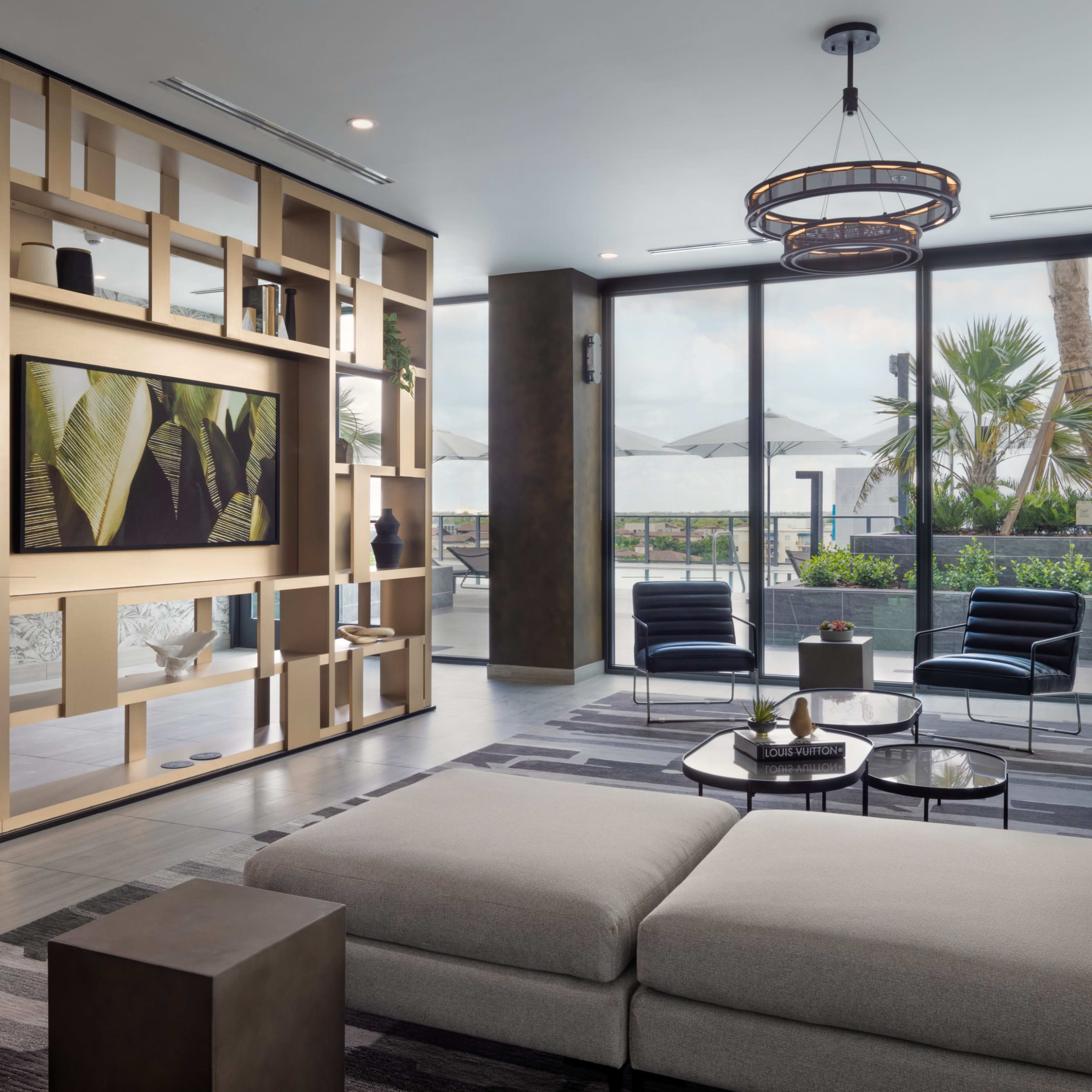 A modern living room features a large sectional sofa, a coffee table, and a wall-mounted television surrounded by decorative shelving.