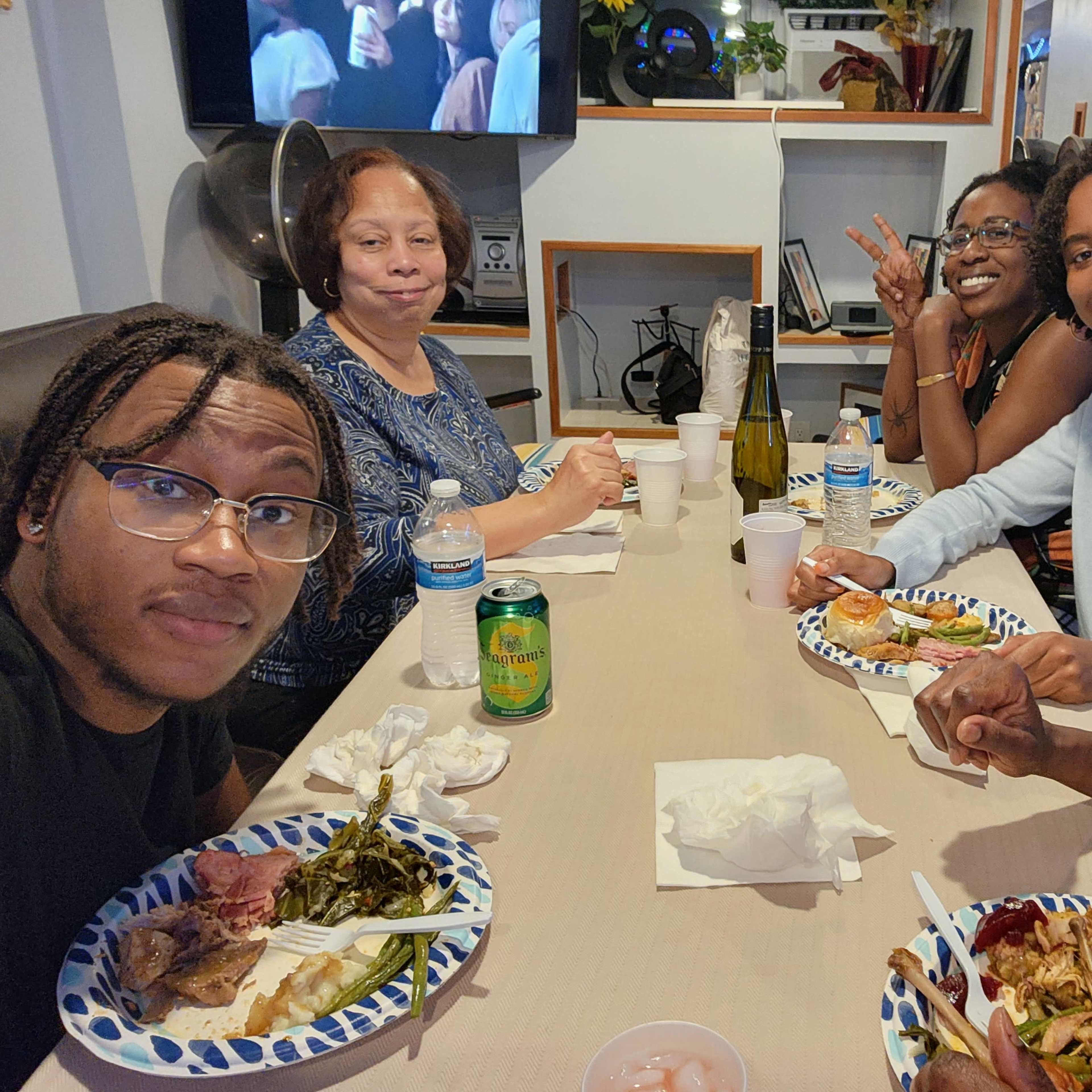 A group of five people sits at a table, enjoying a meal together.