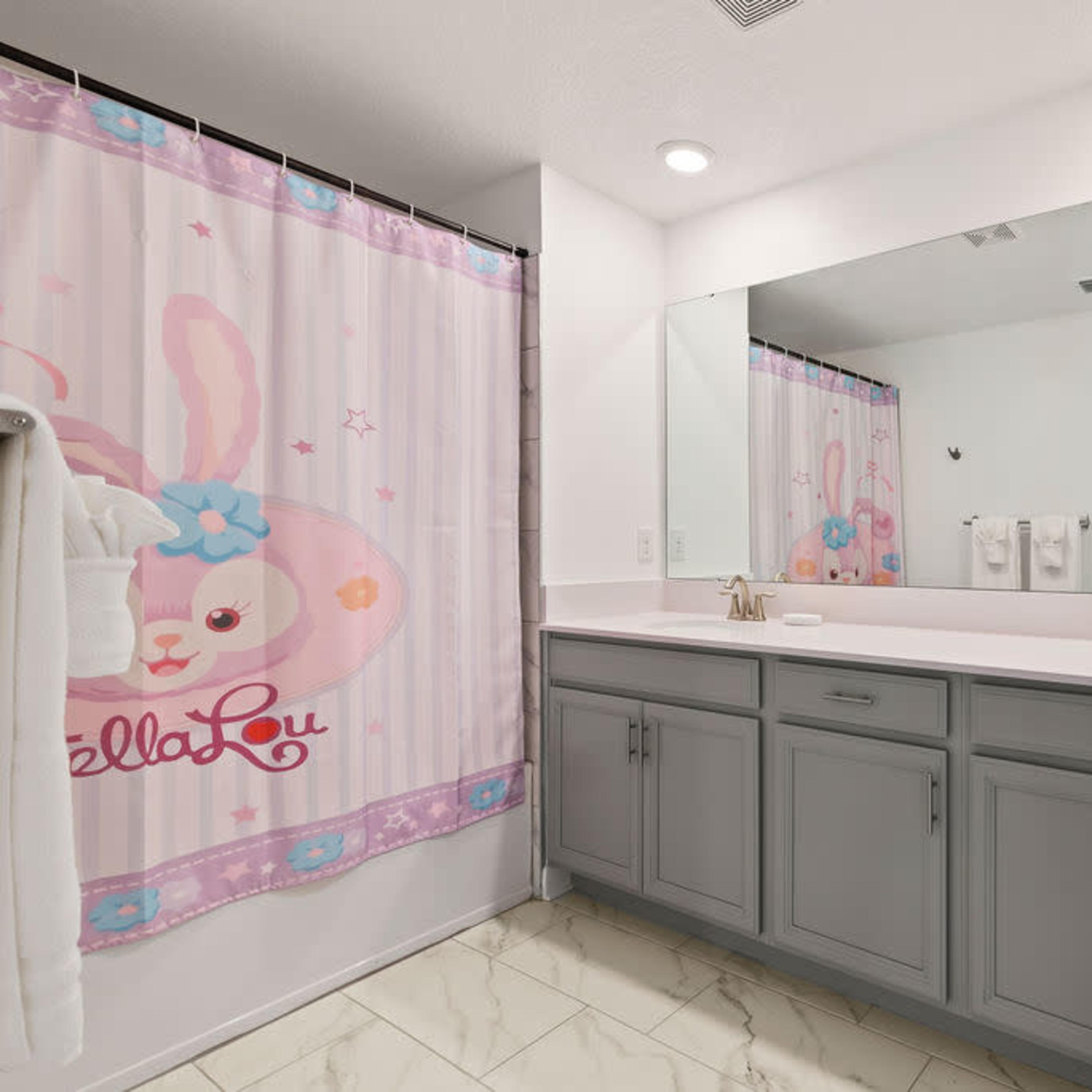 A bathroom with a double vanity, a pink-themed shower curtain featuring a bunny design, and light-colored tile flooring.
