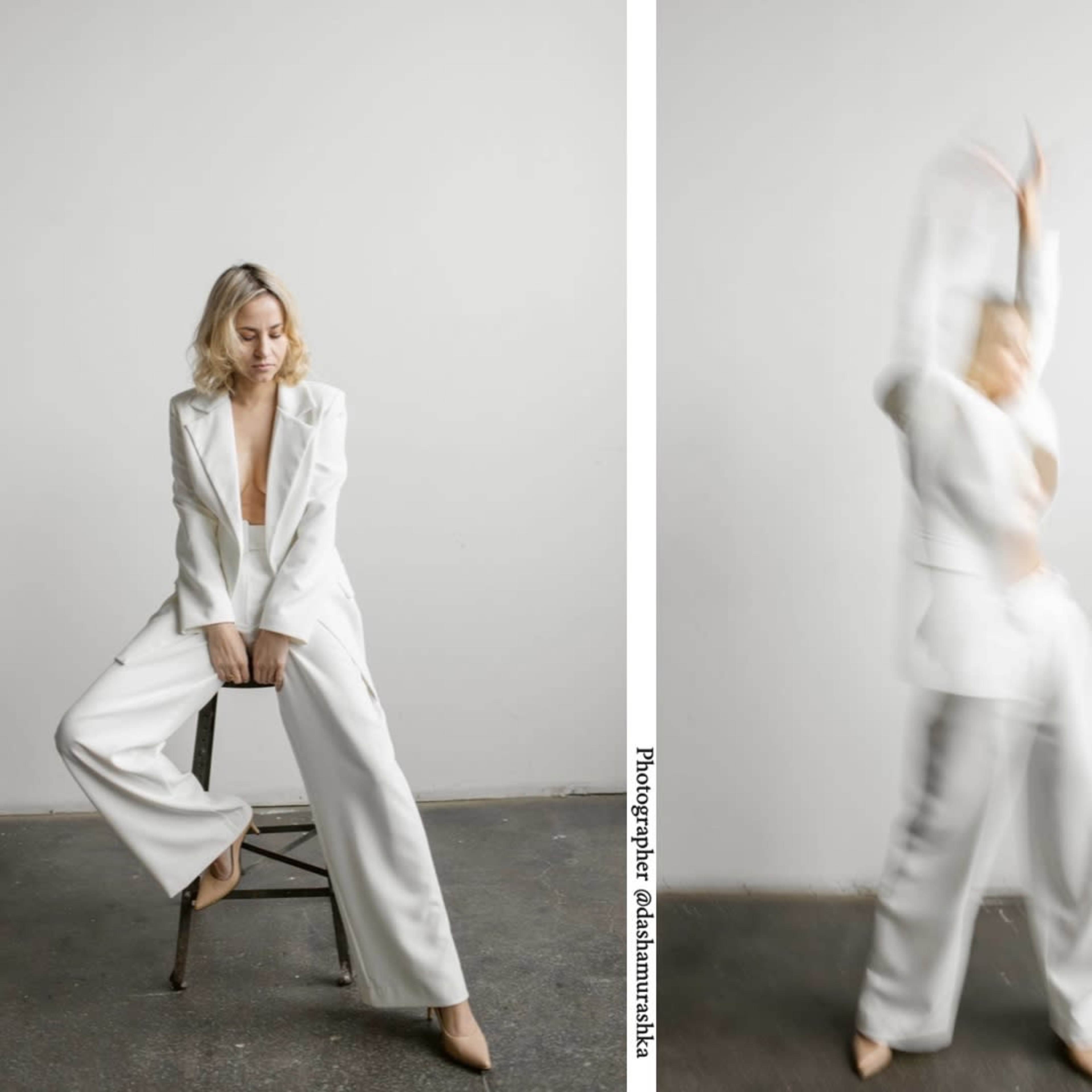 A person wearing a white suit poses in a studio with a minimalist backdrop, showcasing different stances and movements.