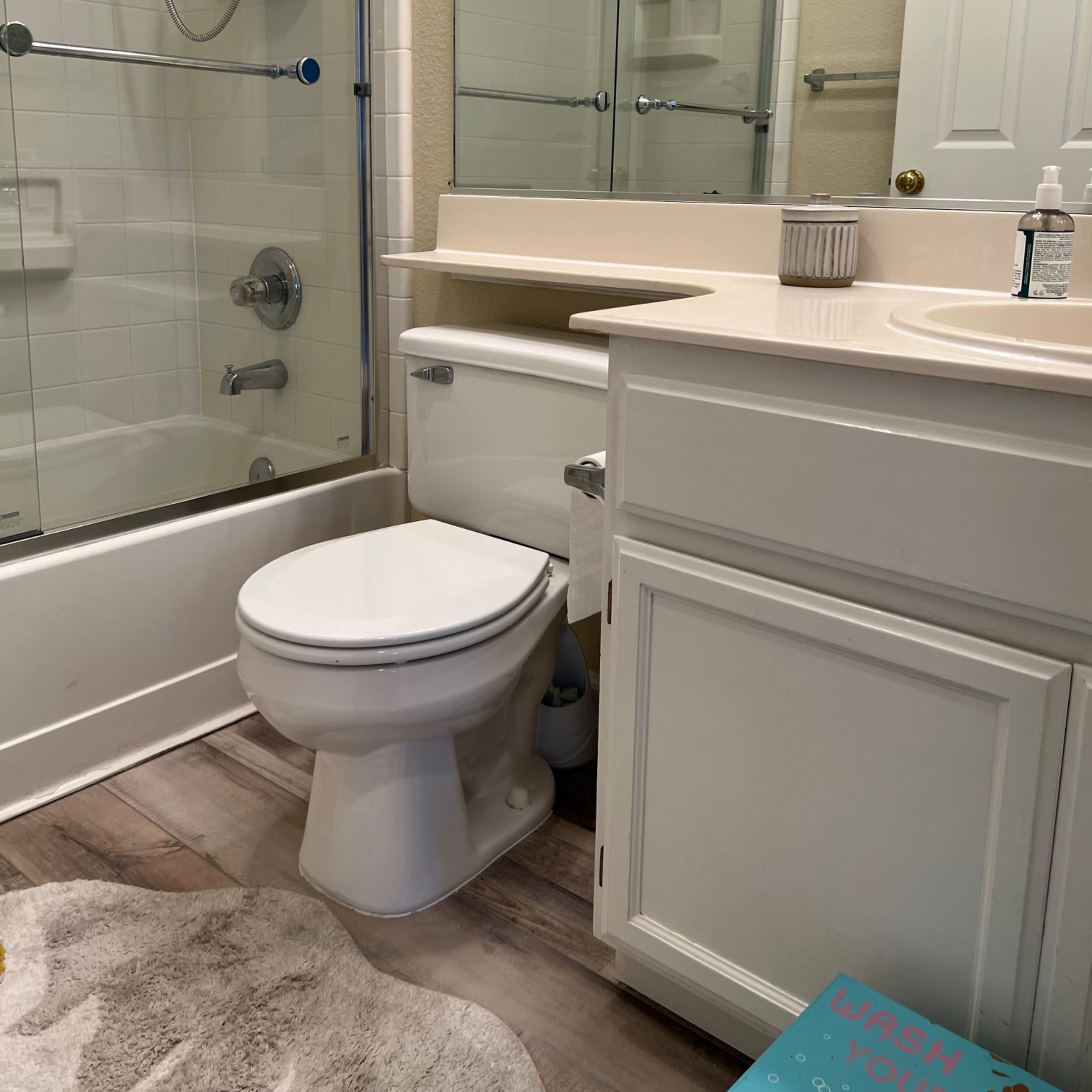A bathroom featuring a shower with glass doors, a toilet, and a sink with a countertop.