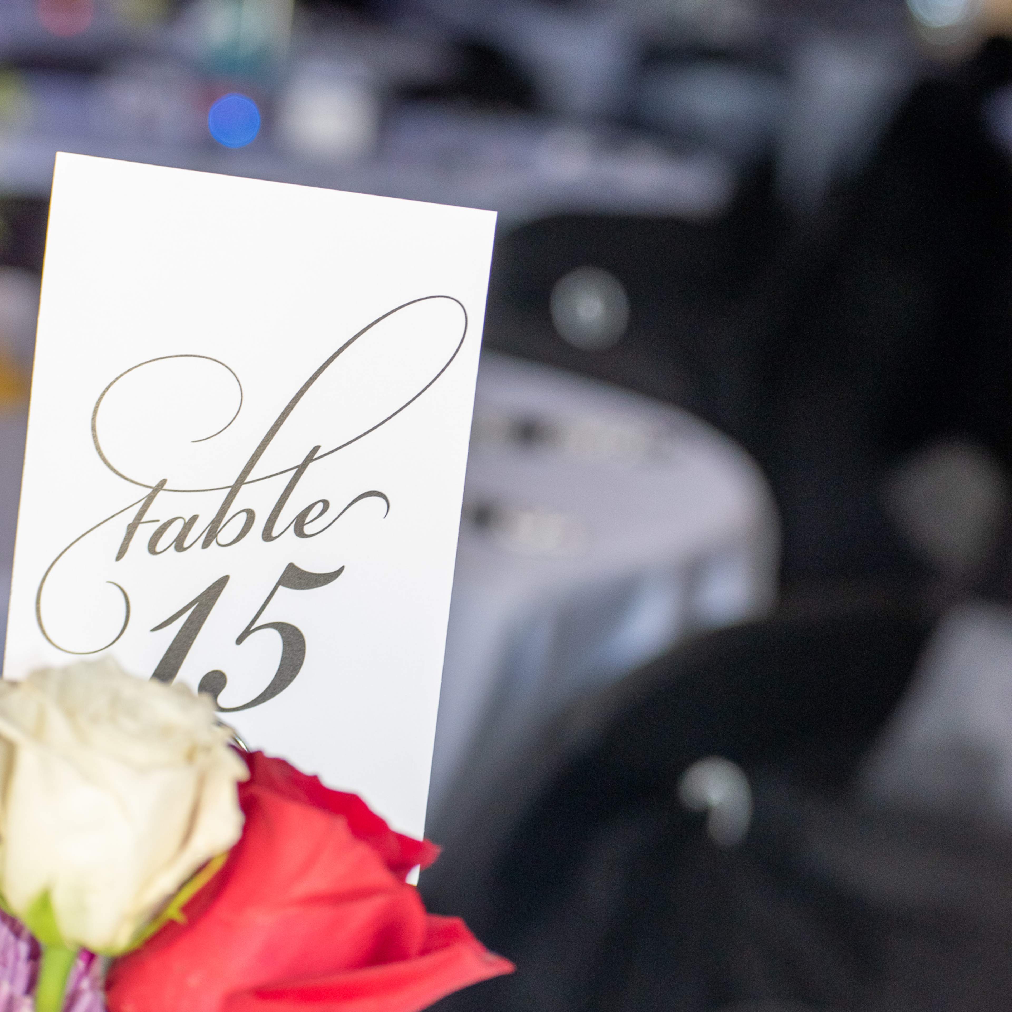 A table setting displays a card labeled "Table 15" alongside a bouquet of roses.