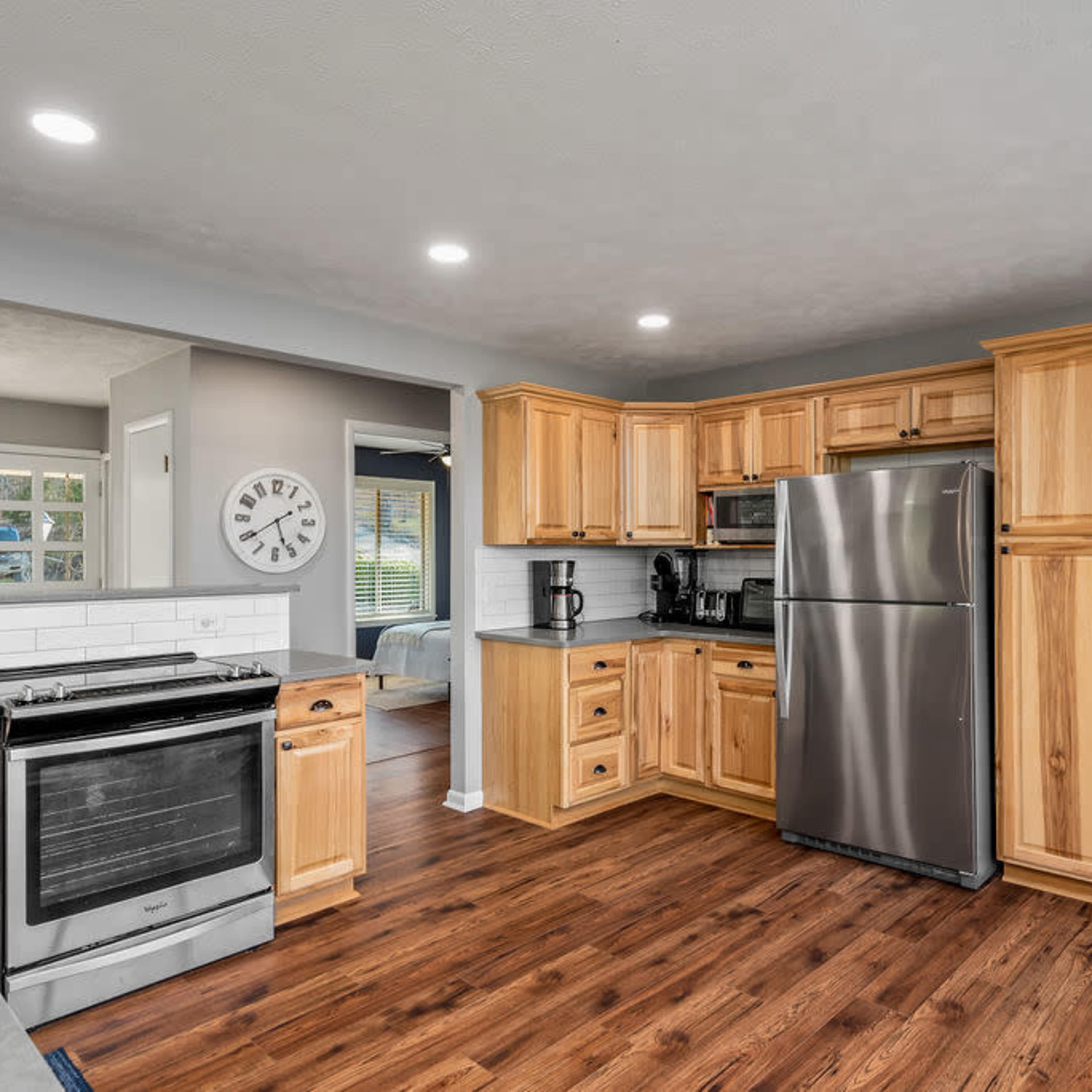 A modern kitchen featuring wooden cabinetry, stainless steel appliances, and a countertop with a seating area.