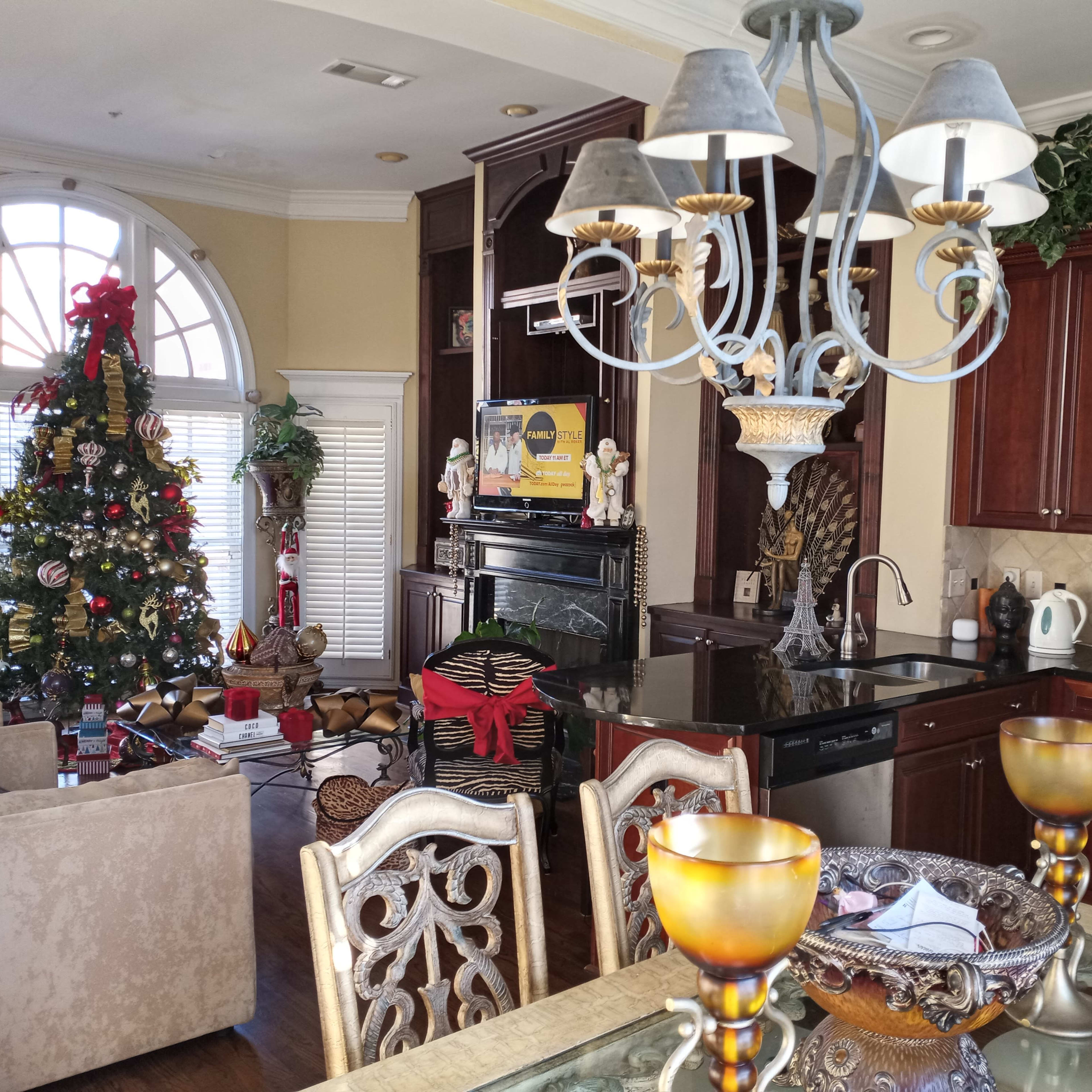 A kitchen and living room area decorated for the holidays, featuring a Christmas tree and various decorations.