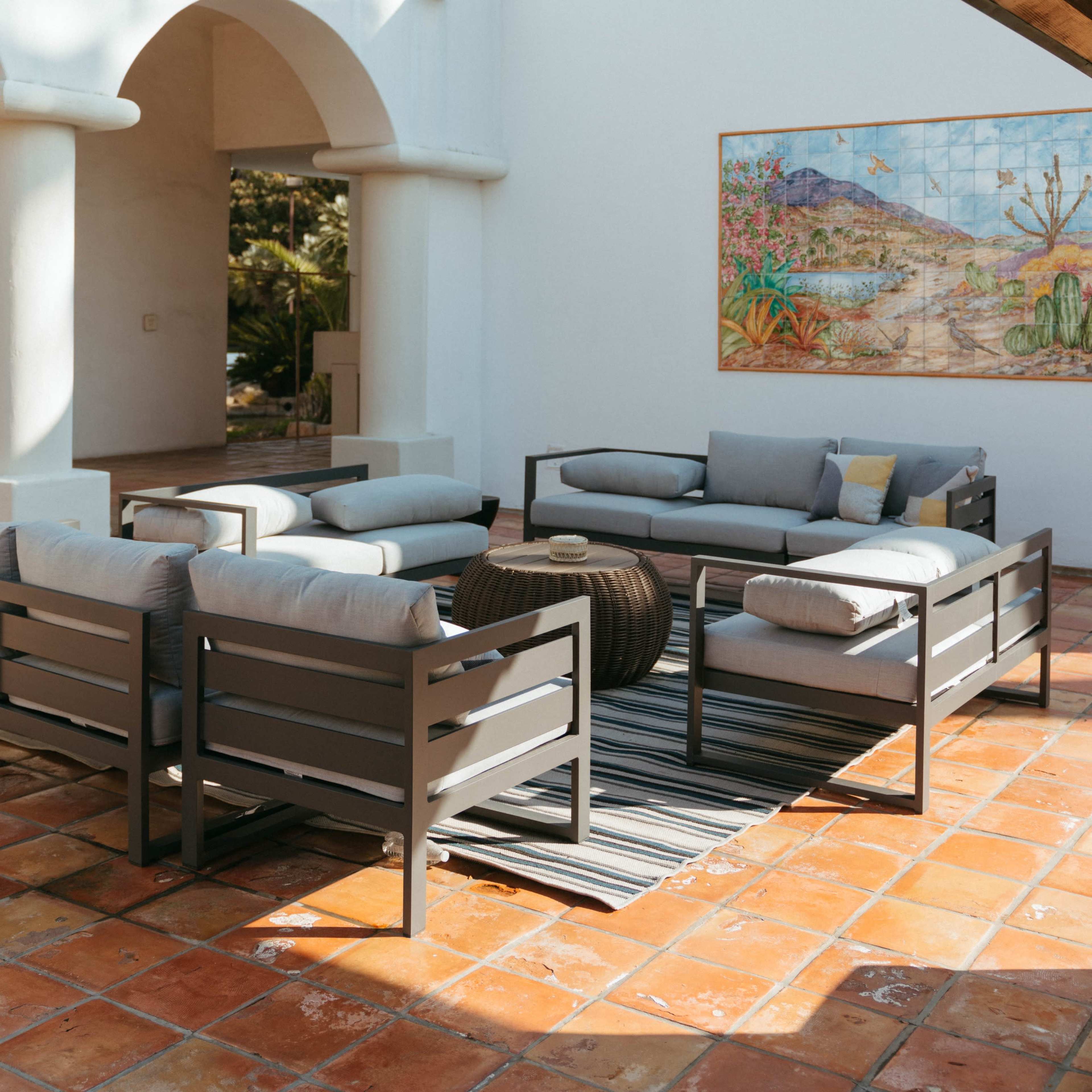 A patio area with modern seating arrangements and a large mural featuring a tropical scene.