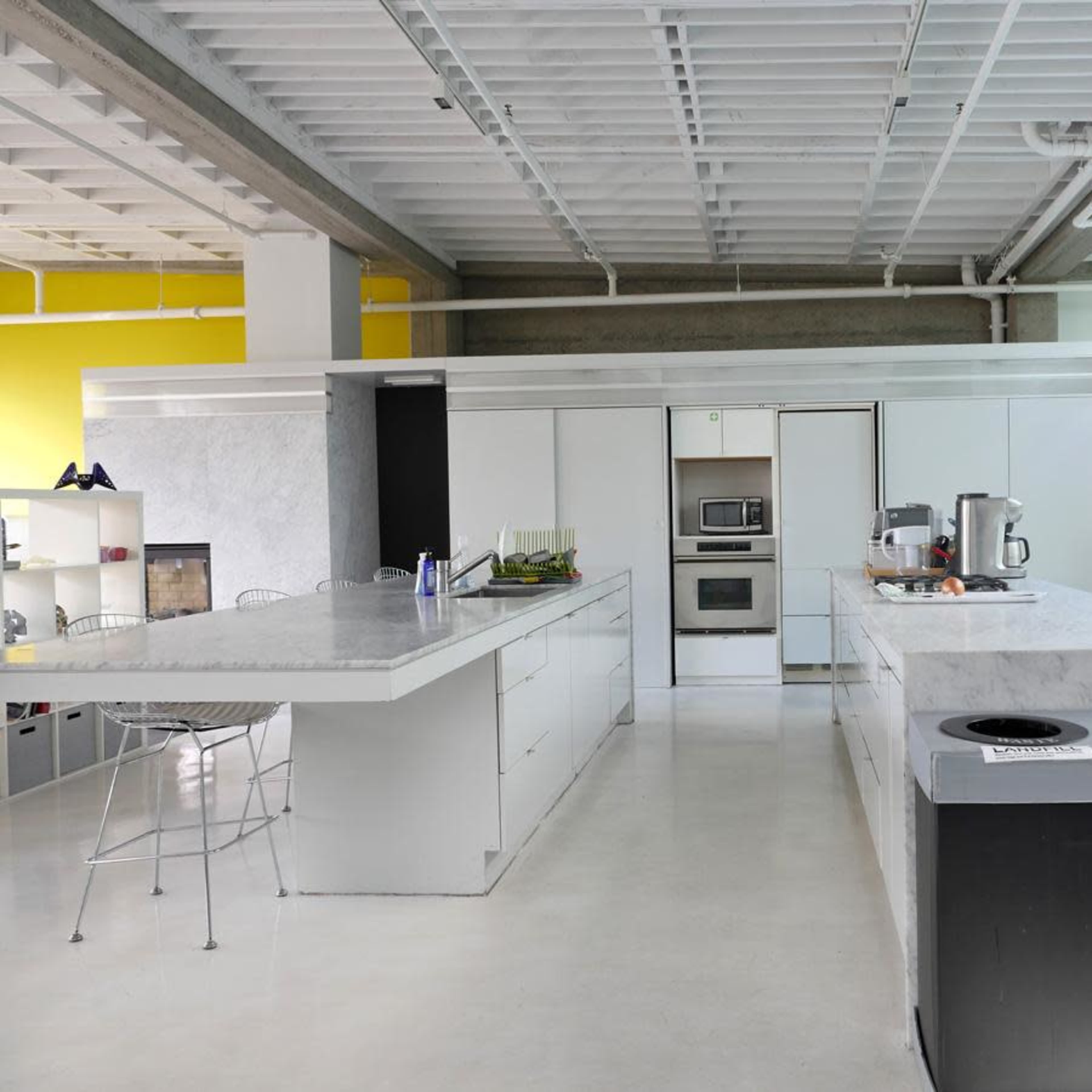 A modern kitchen with a large central island, stainless steel appliances, and minimalistic cabinetry.