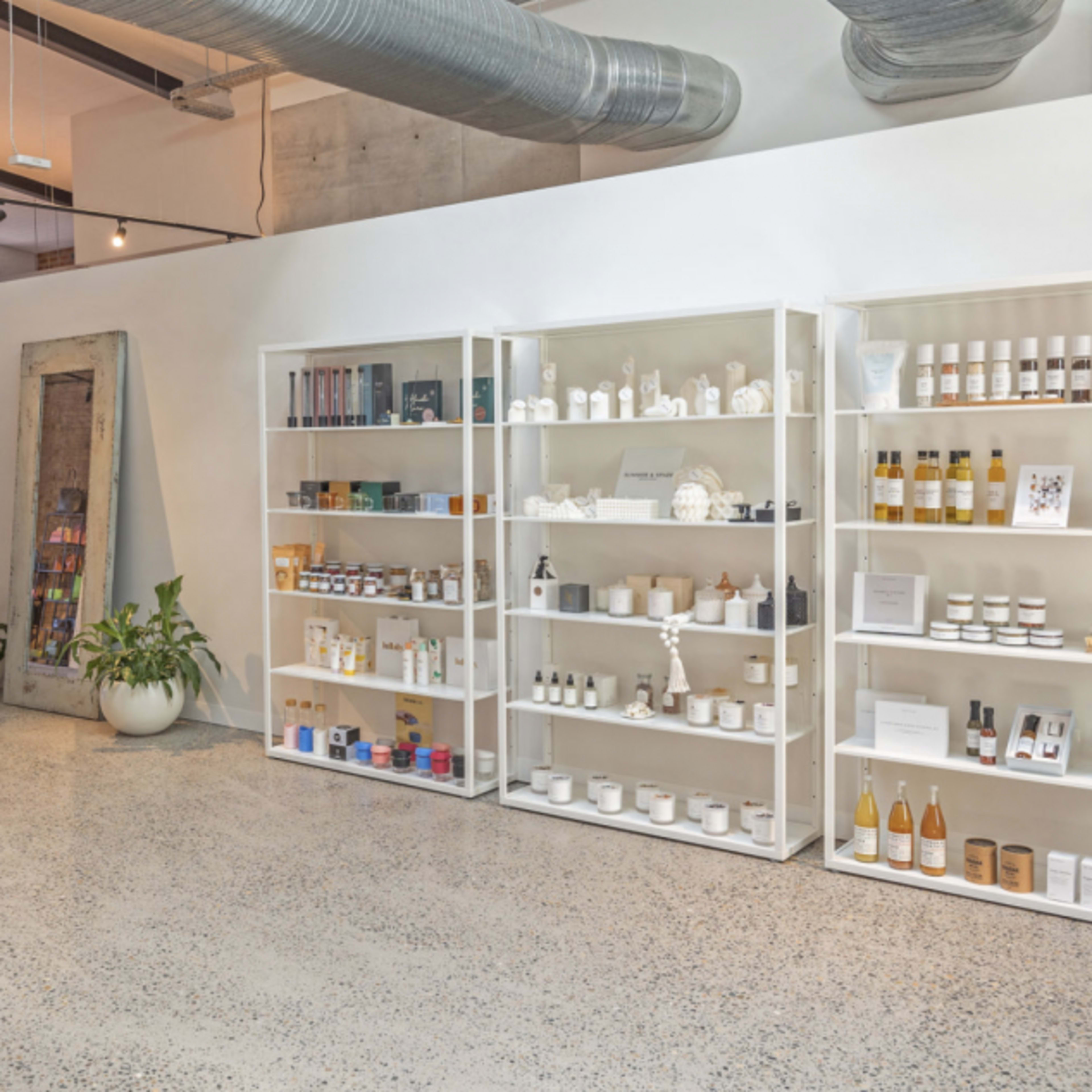 A clean, well-organized interior space featuring white shelves stocked with various skincare and wellness products.
