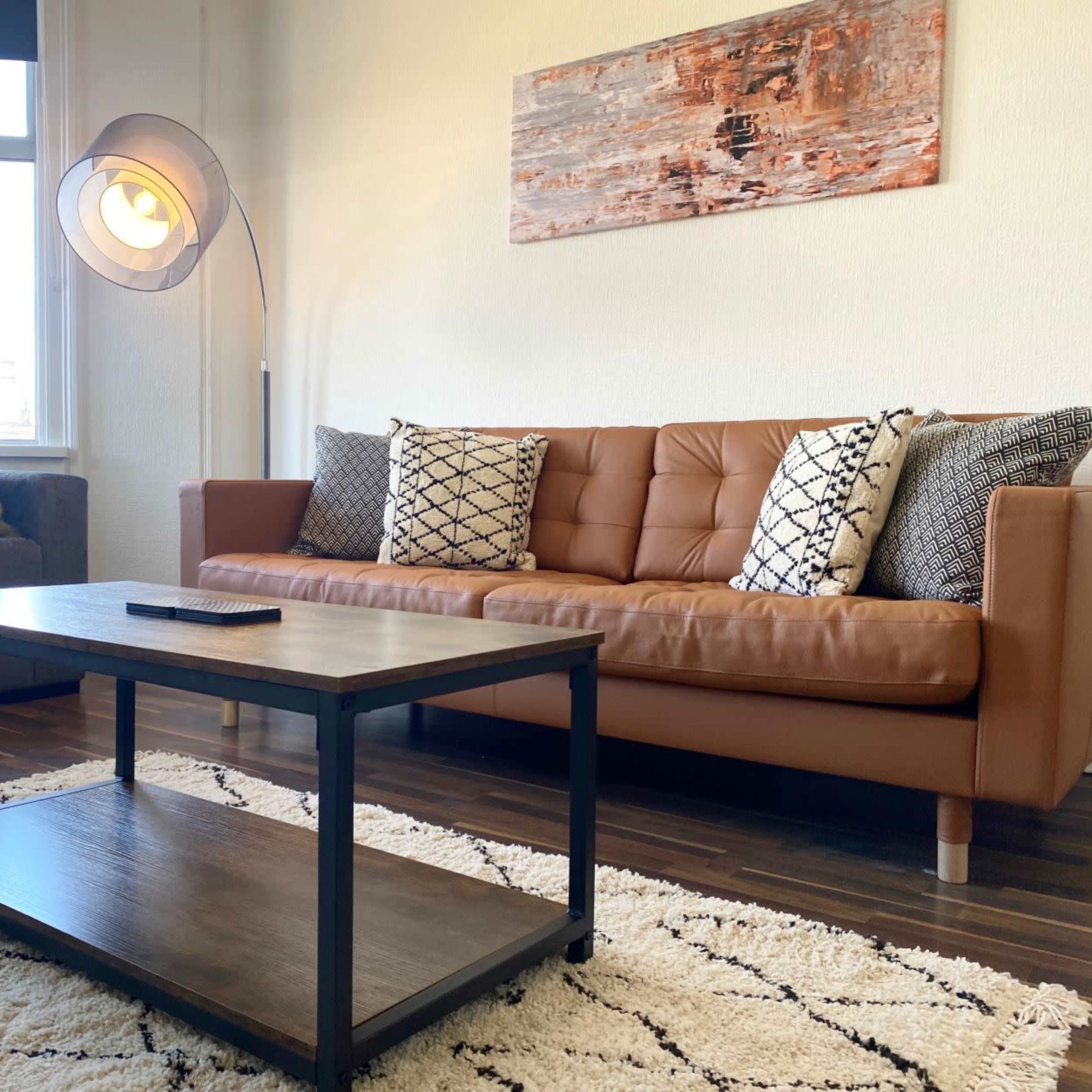 A living room with two sofas, a coffee table, and a rug on wooden flooring.