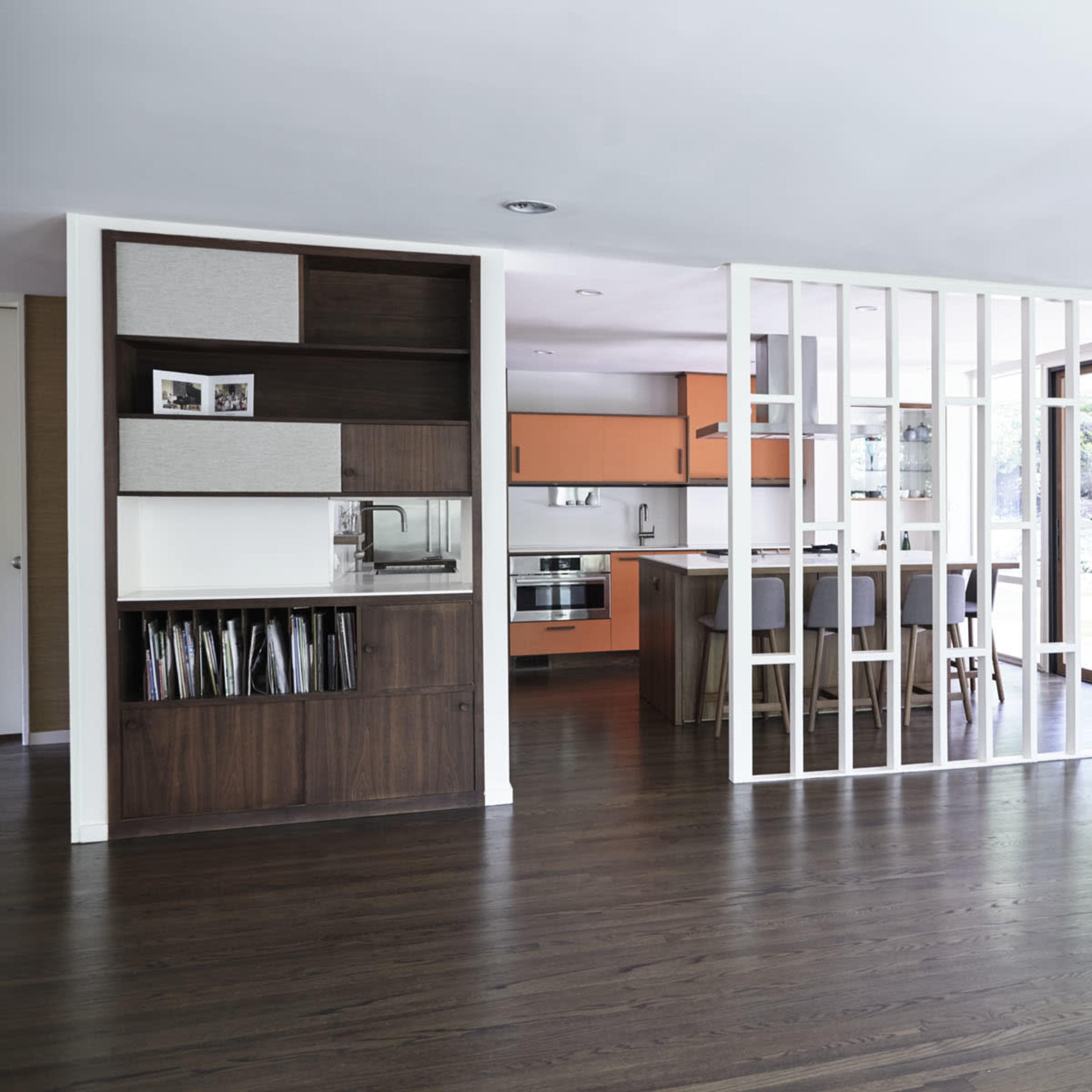 A modern, open-concept living space with a kitchen, dining area, and a partial room divider.