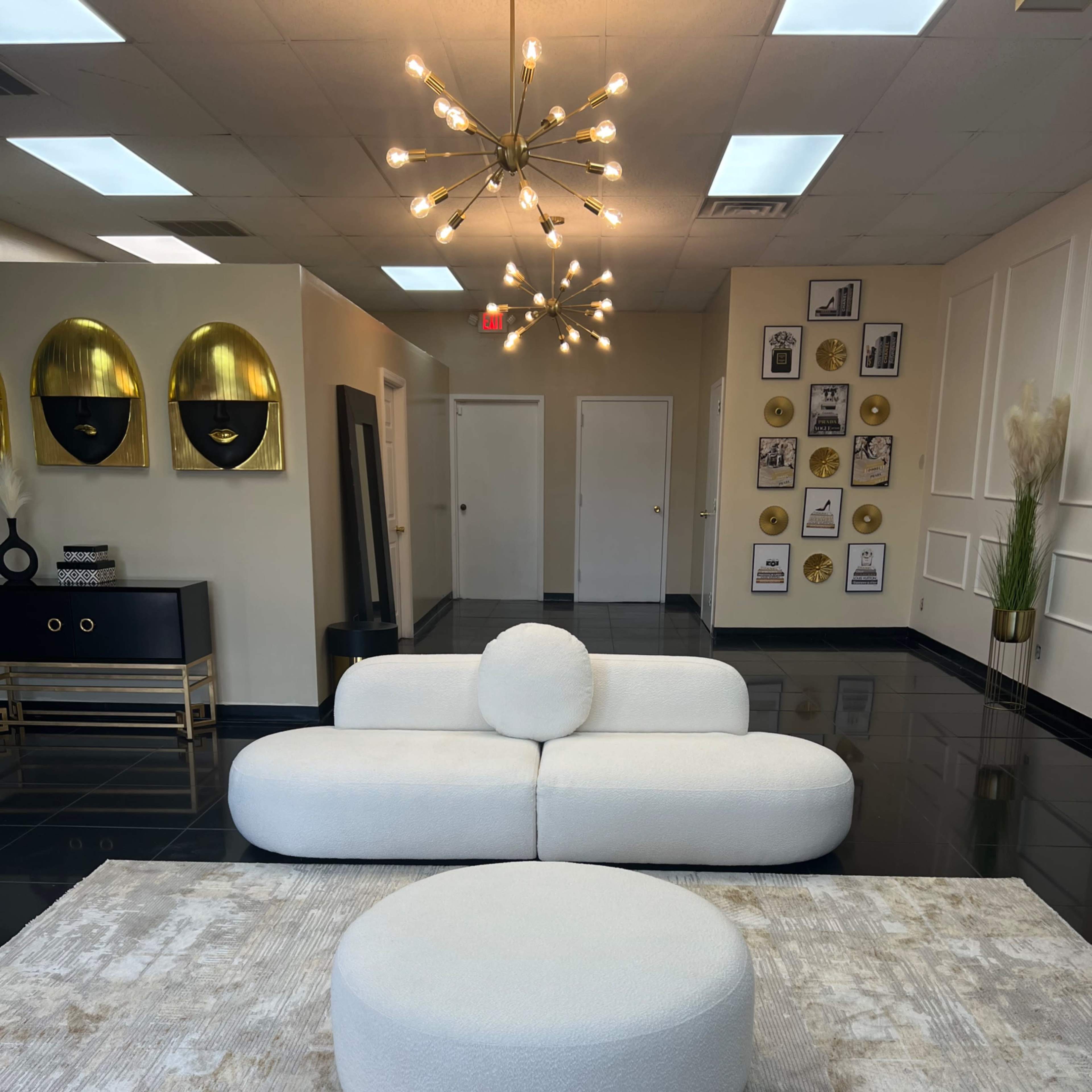 A modern interior with a white sofa and round coffee table, highlighted by a unique light fixture and decorative wall art.