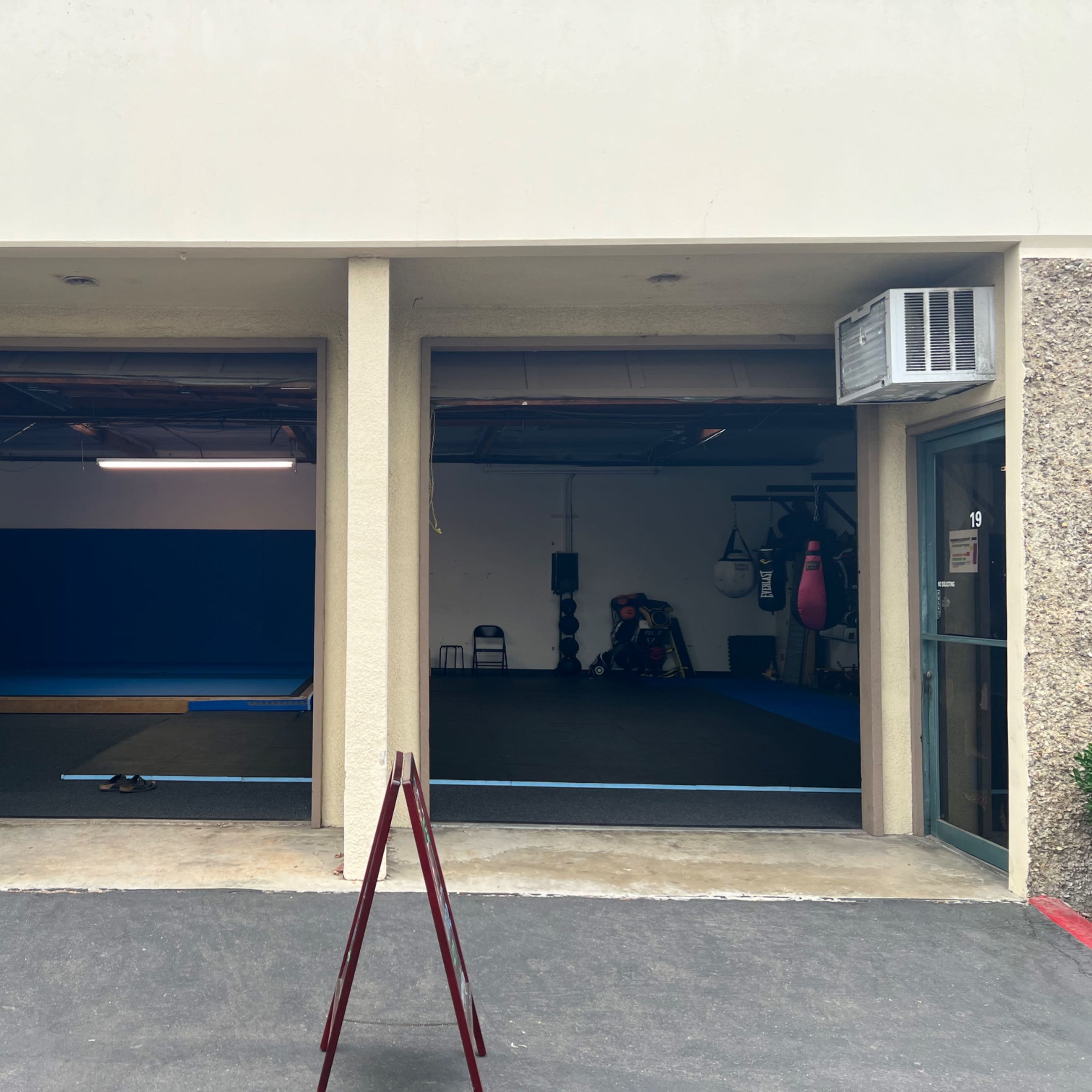 Two open gym entrances with blue flooring and workout equipment visible inside.