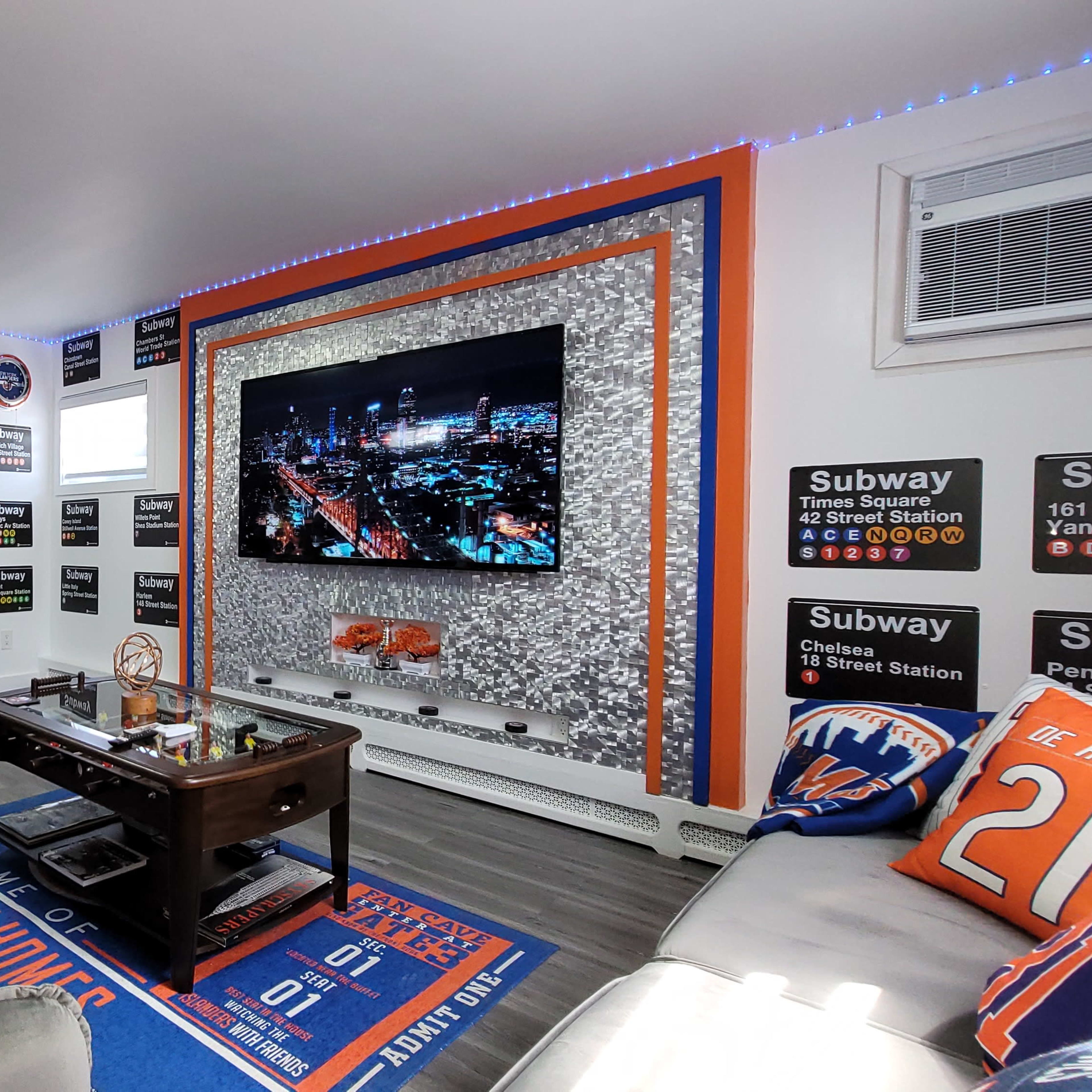 A themed living room decorated with sports memorabilia, including a large TV screen, a coffee table, and various couch cushions representing a sports team.