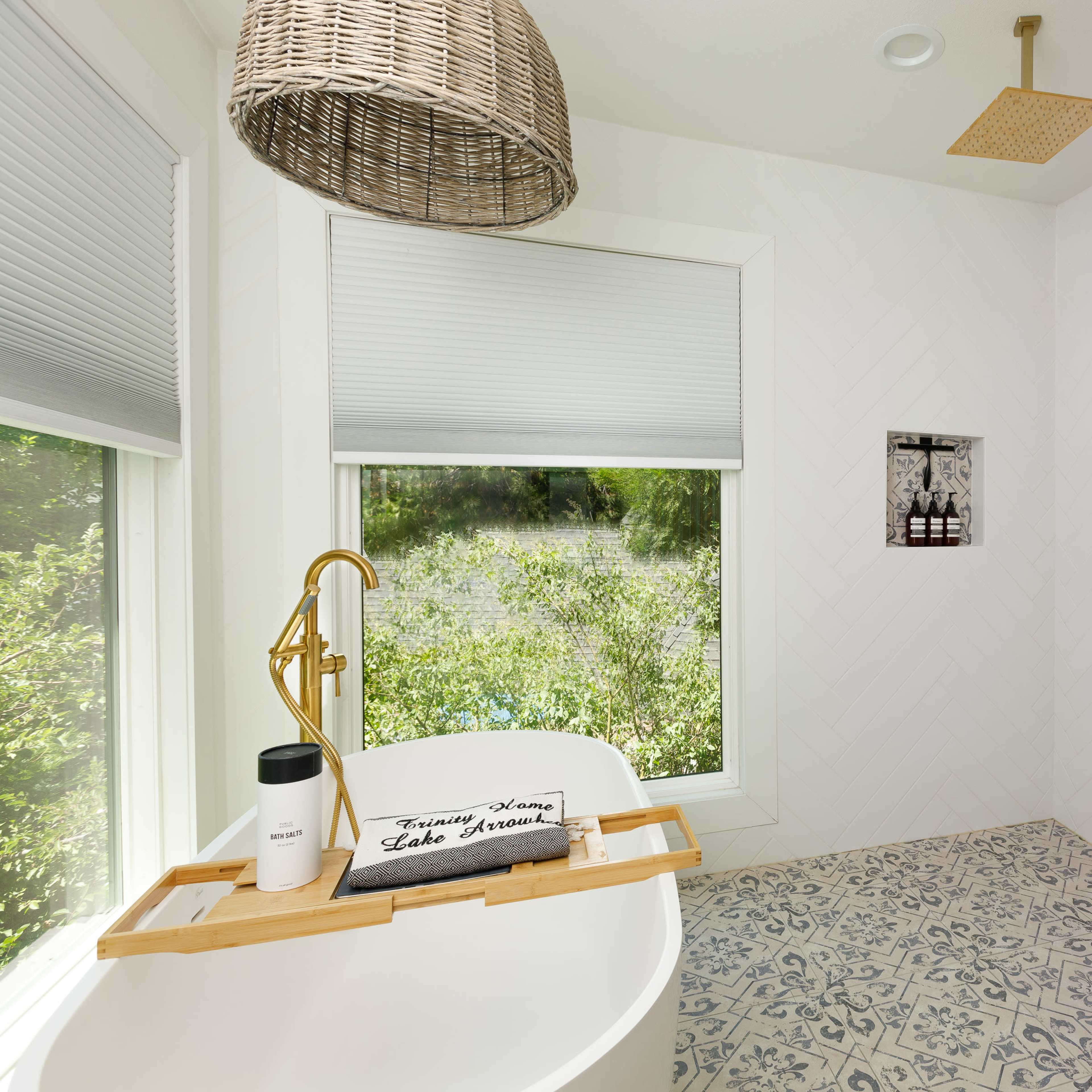 A modern bathroom featuring a freestanding bathtub, a walk-in shower with glass doors, and a patterned tile floor.