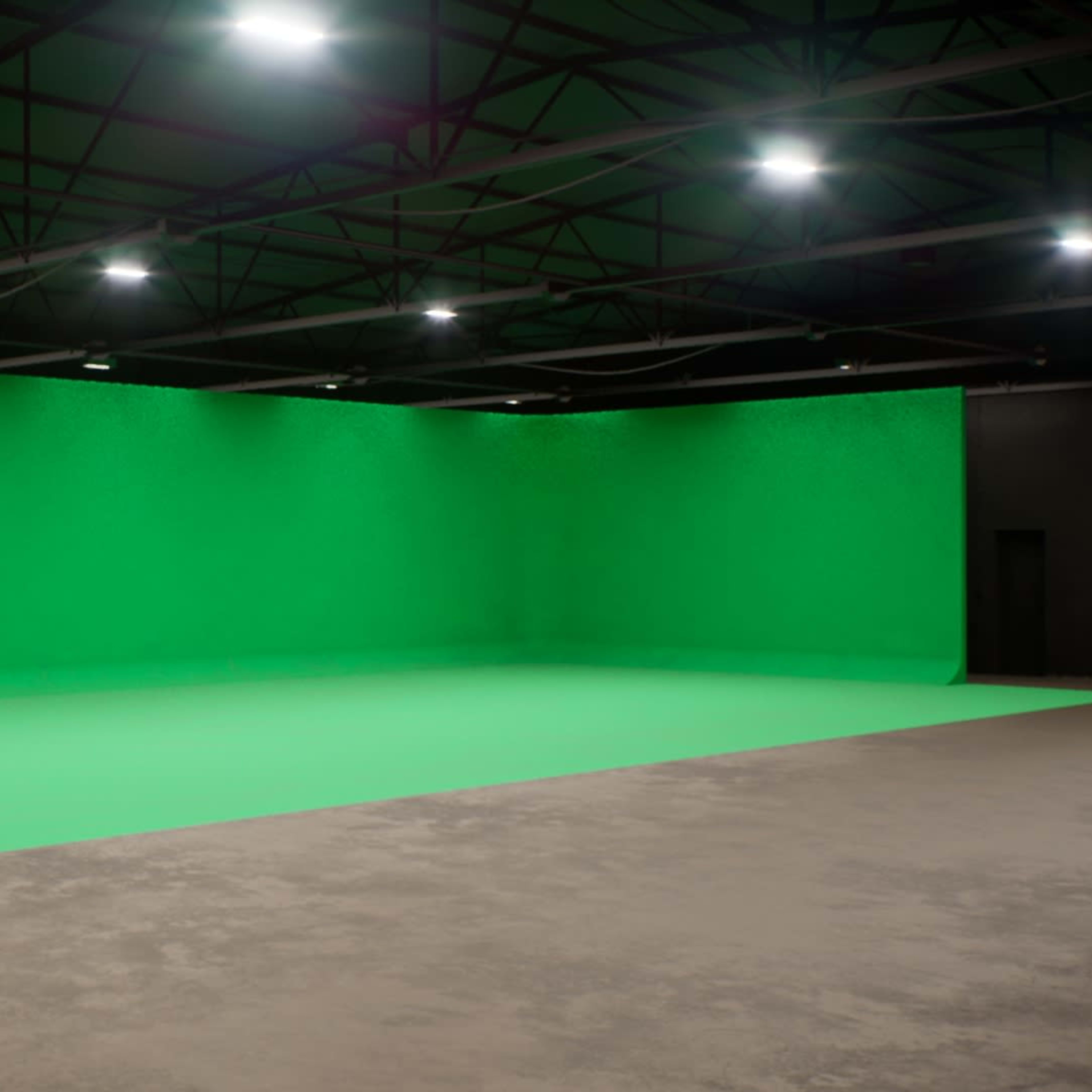 A large green screen setup in a spacious studio with overhead lighting.