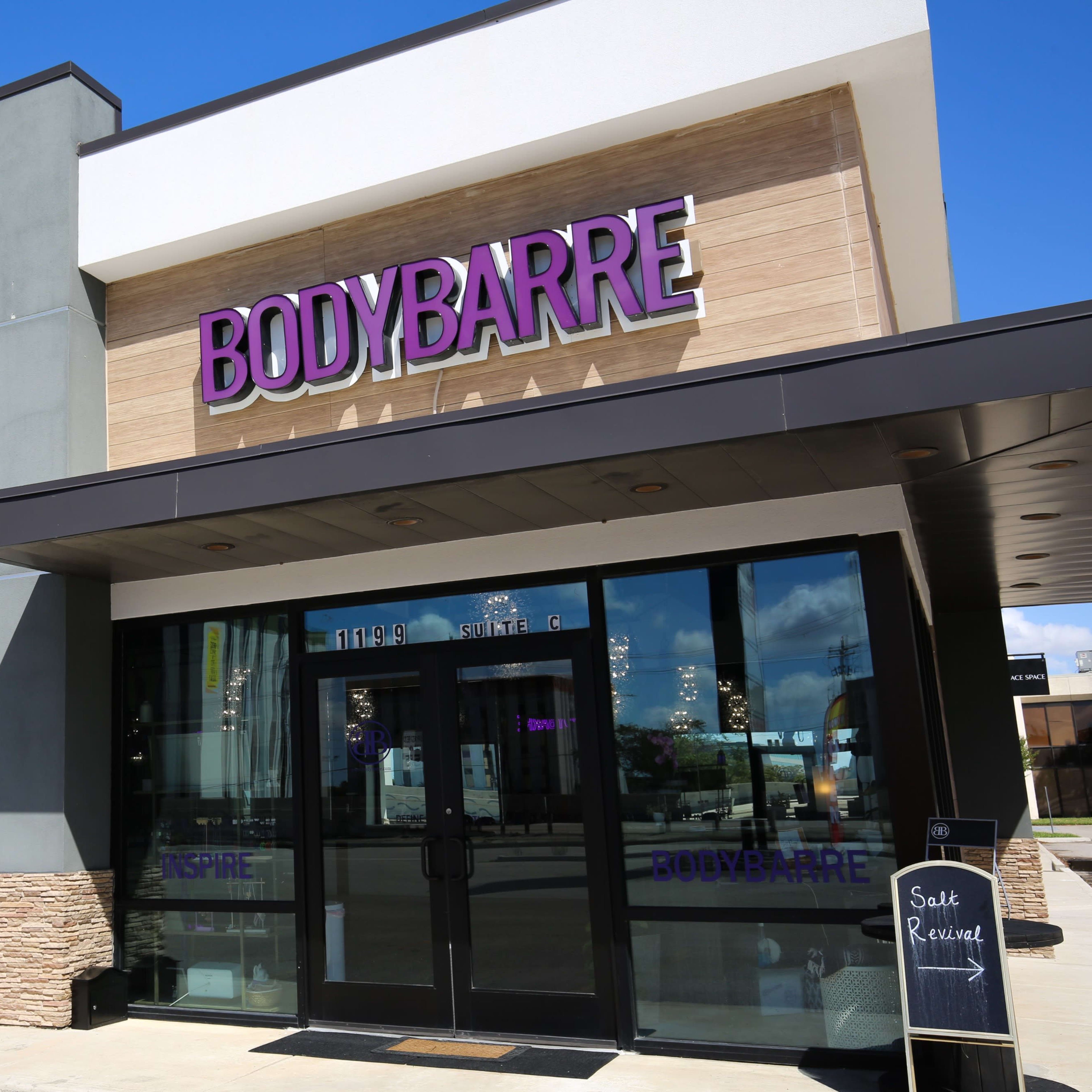 A commercial building featuring a storefront for "BodyBarre" and a side entrance to a salt therapy studio.