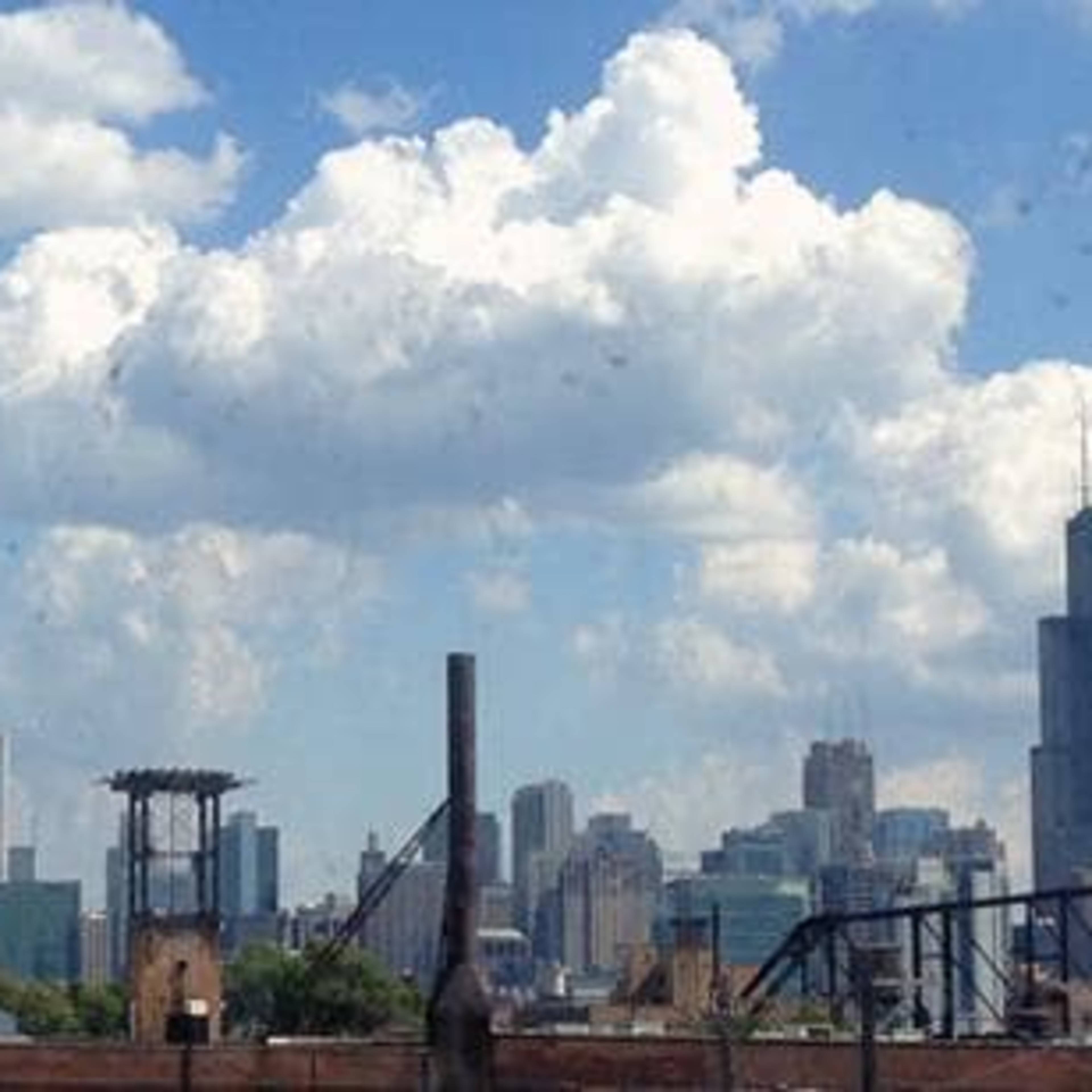 A panoramic view of the Chicago skyline under a partly cloudy sky.