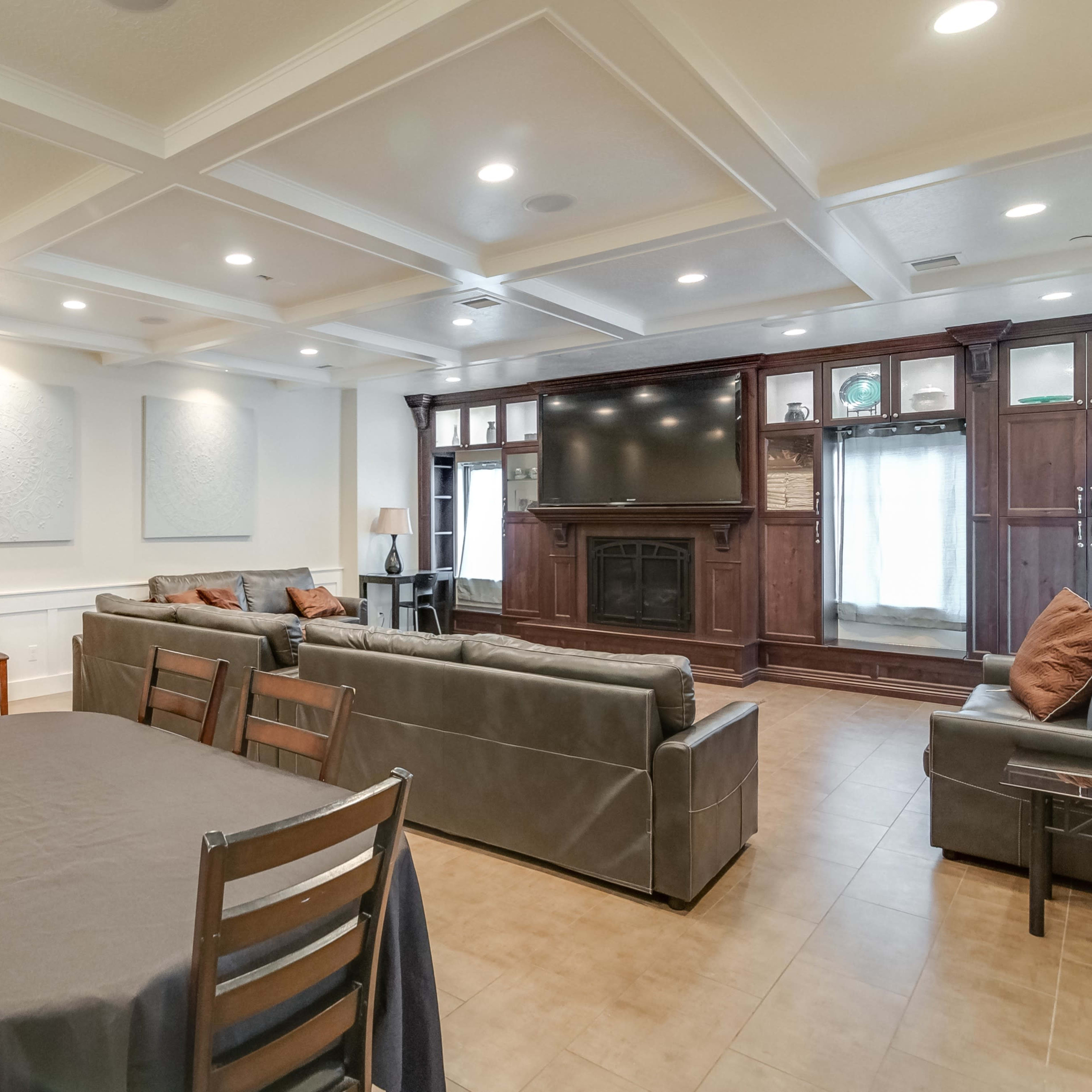 The room features a spacious layout with multiple seating areas, a television unit, and tables covered with dark tablecloths.